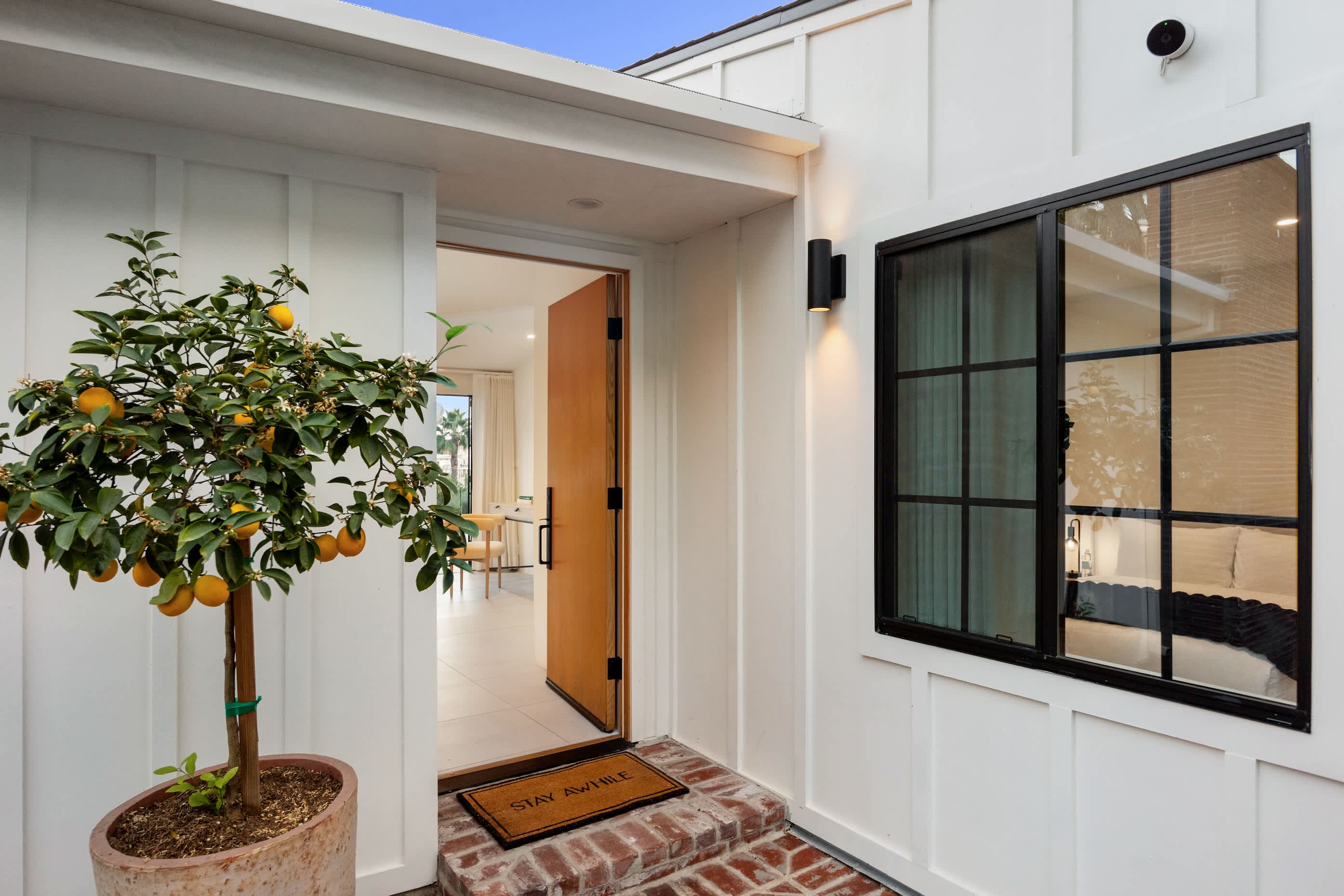 Step into charm, where a brick pathway and natural greenery welcome you home.