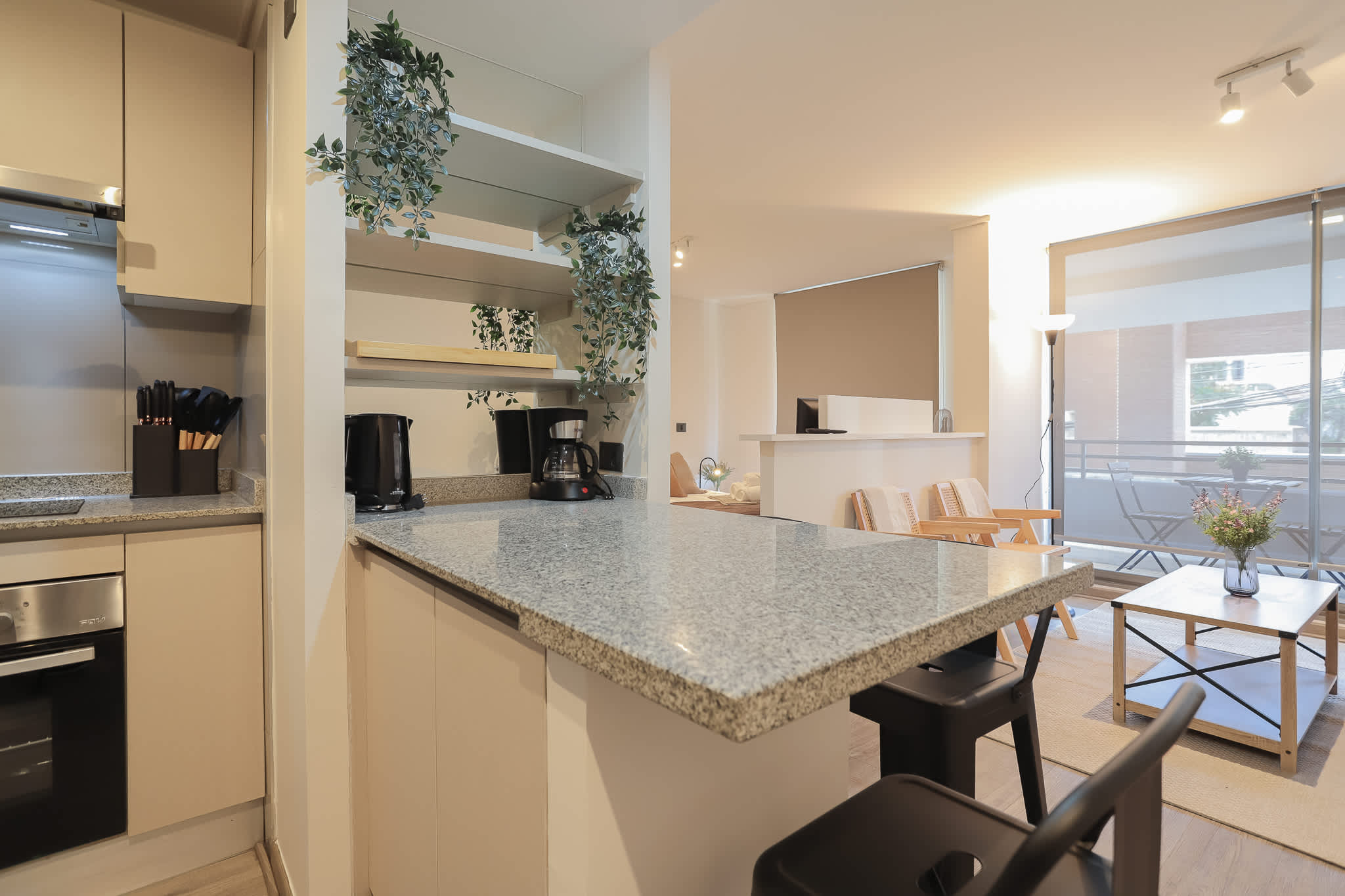 Cocina equipada con electrodomésticos de acero inoxidable, encimeras de granito y barra de desayuno.