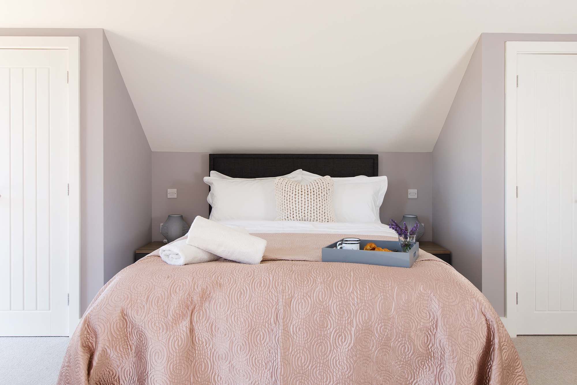 The master bedroom is decorated in soft pinks to create a relaxing space to unwind after a day out exploring this corner of Sussex.
