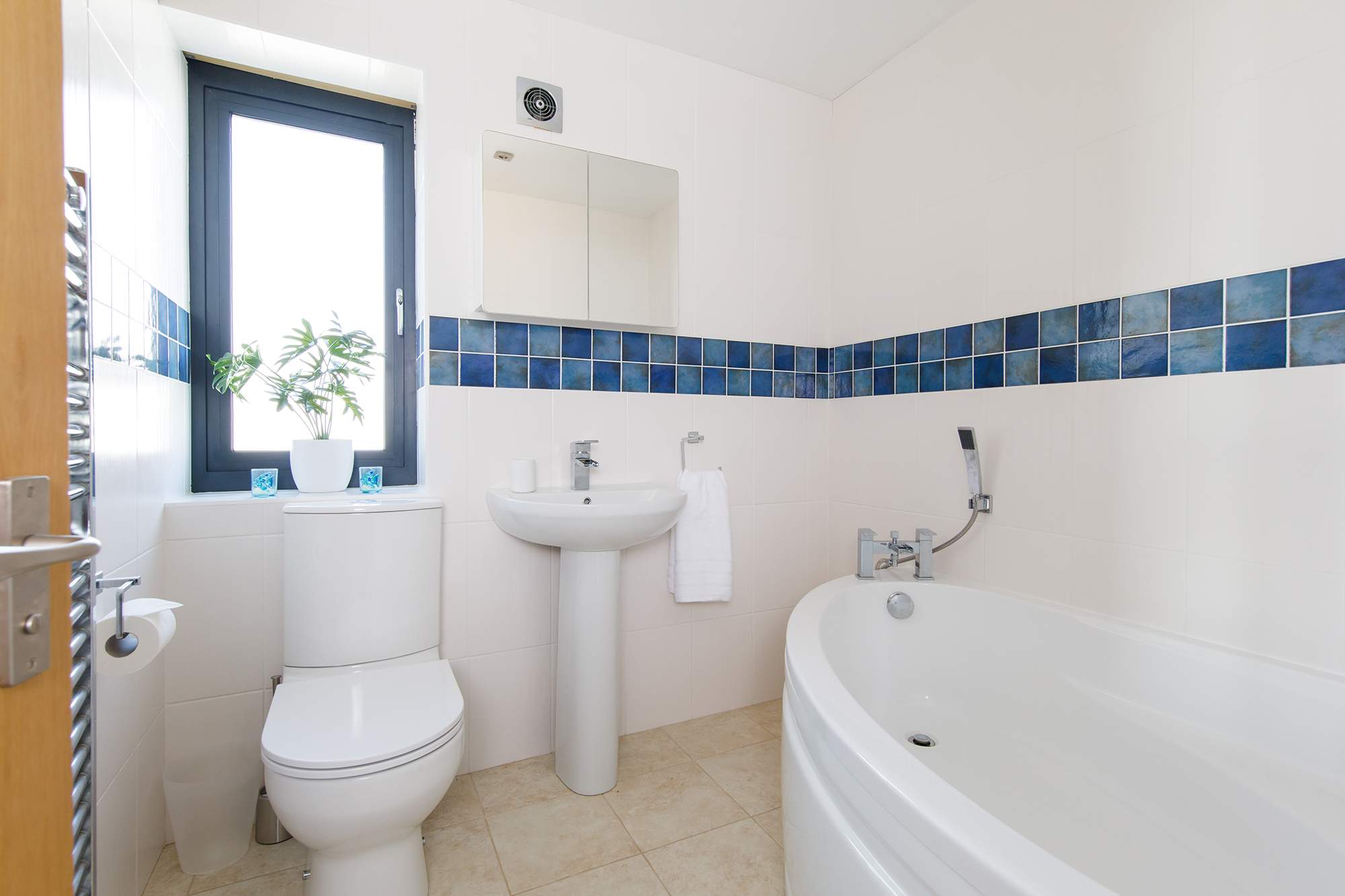 The family bathroom has a large bath, WC and sink.