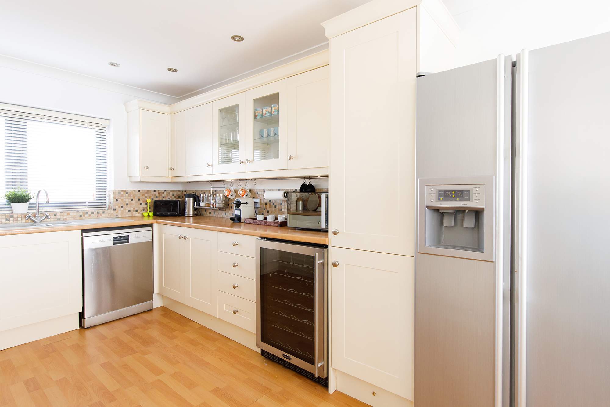 The kitchen has a dishwasher and huge American style fridge freezer.