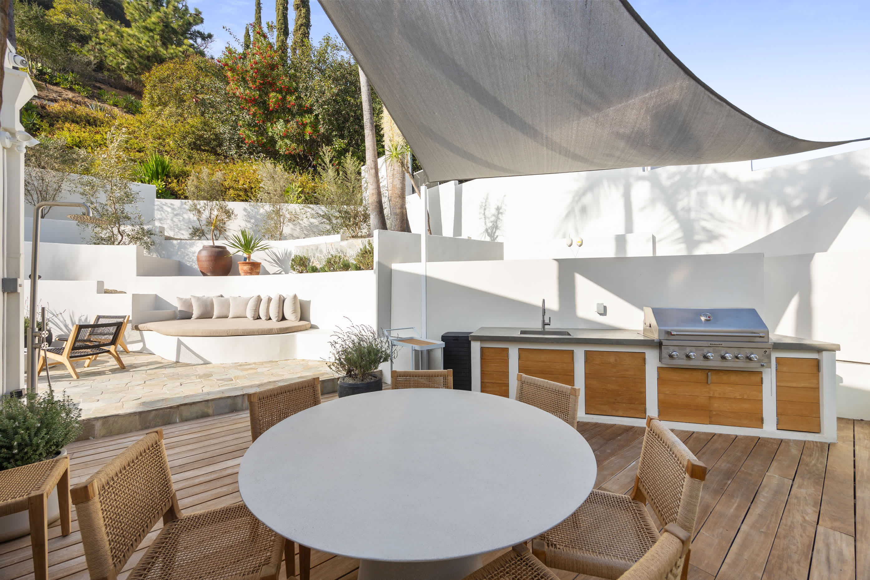 A breezy haven with a chic round table, woven chairs, and dreamy canopy shade.