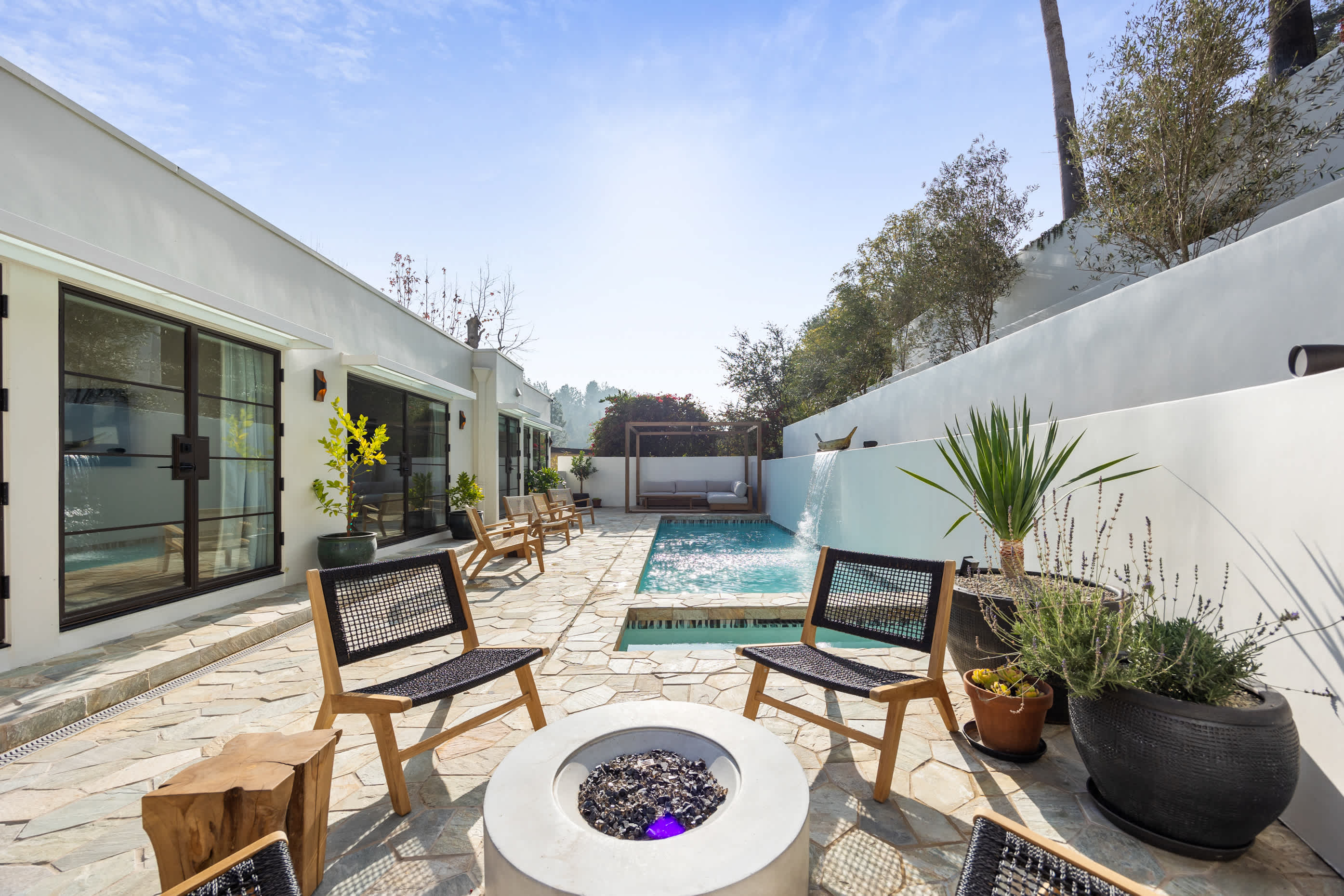 Modern firepit with textured stone surround and contemporary chairs.