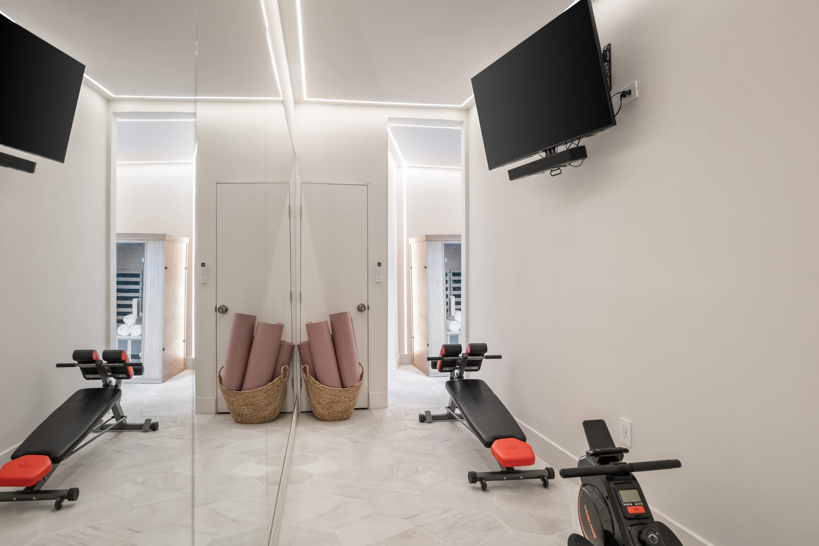 A polished gym with mirrored walls and premium equipment.