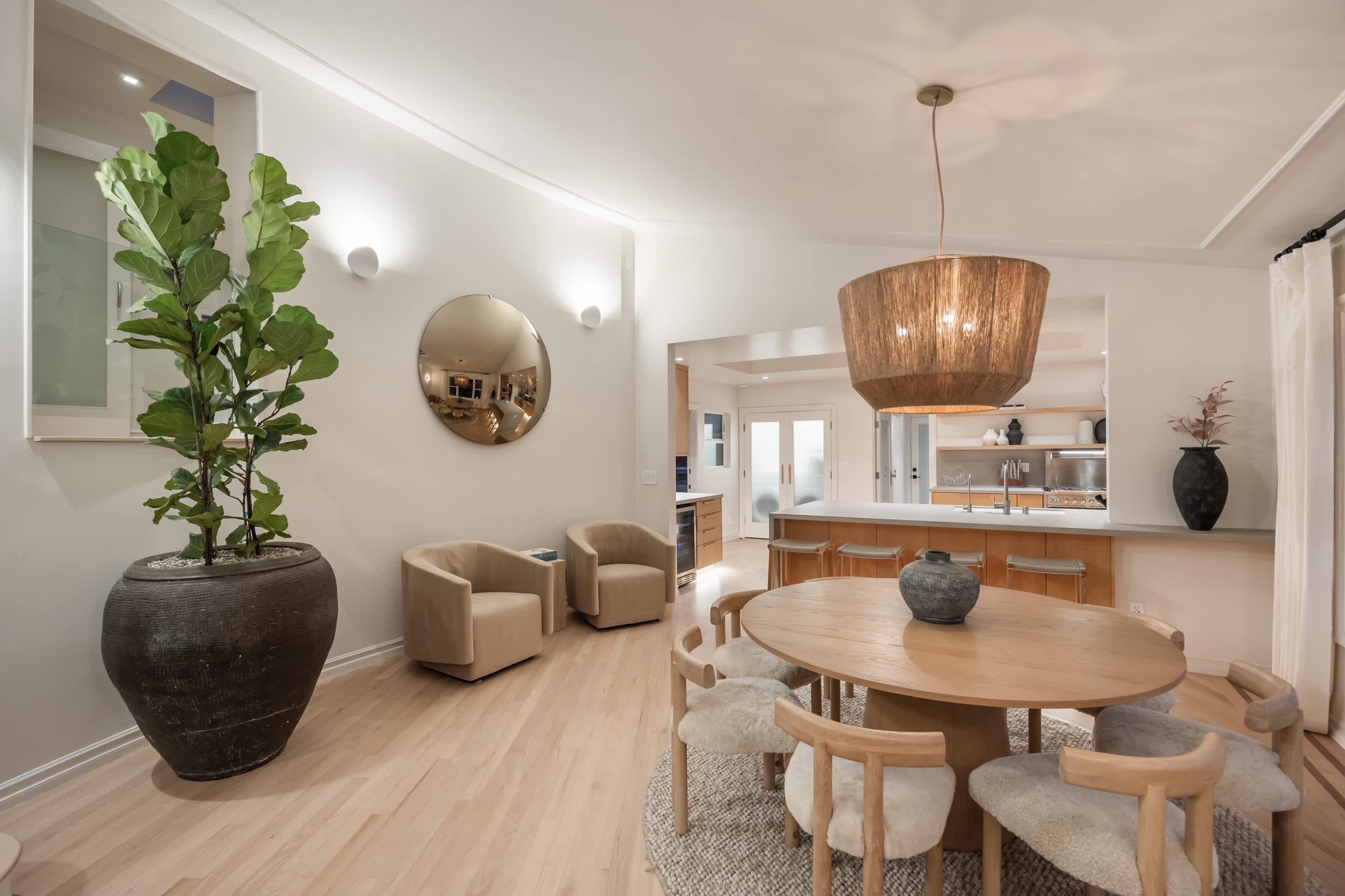 Dine beneath a statement pendant, surrounded by modern design and natural textures