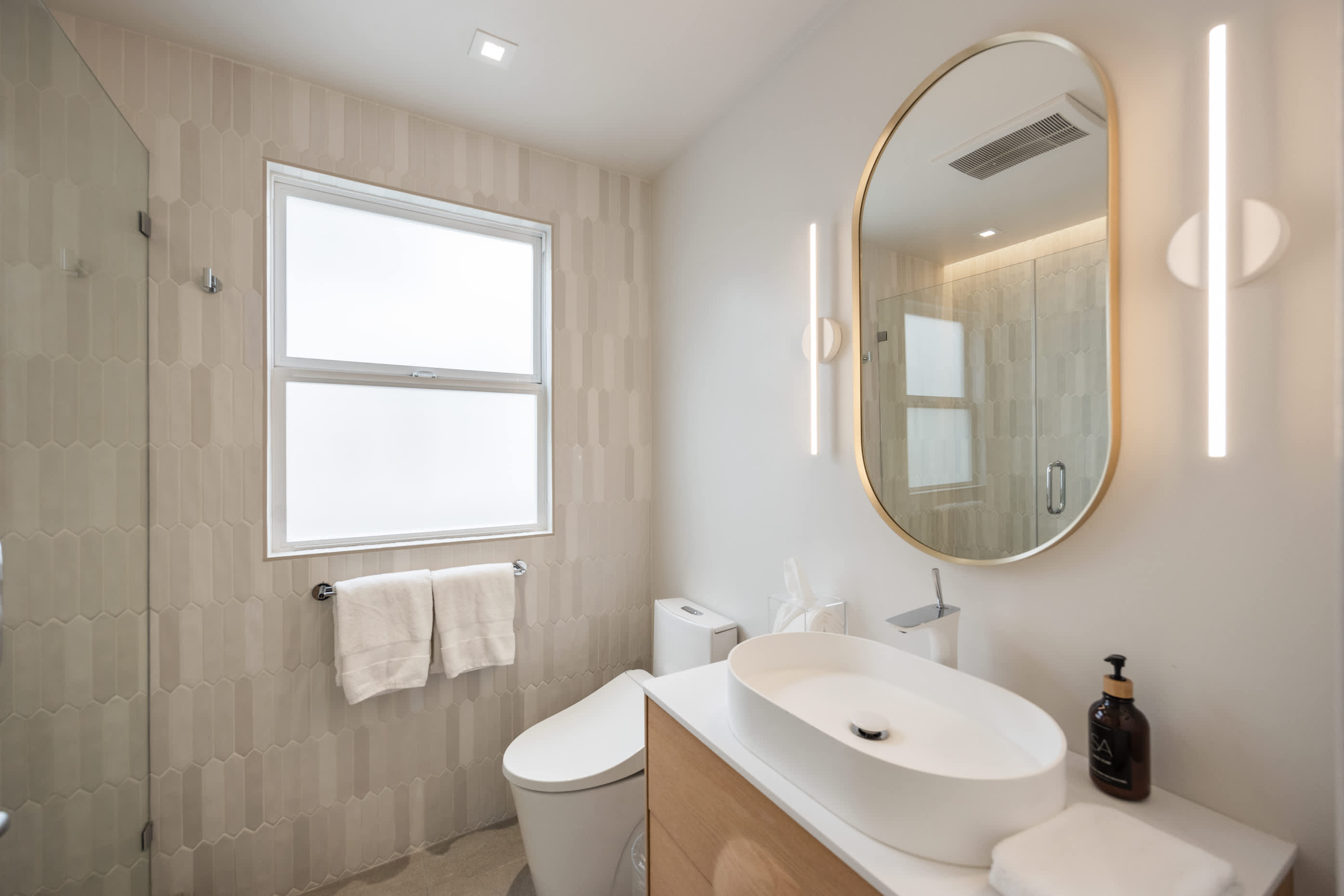 Spa-like bathroom with a floating vanity, illuminated mirror, and sleek fixtures.