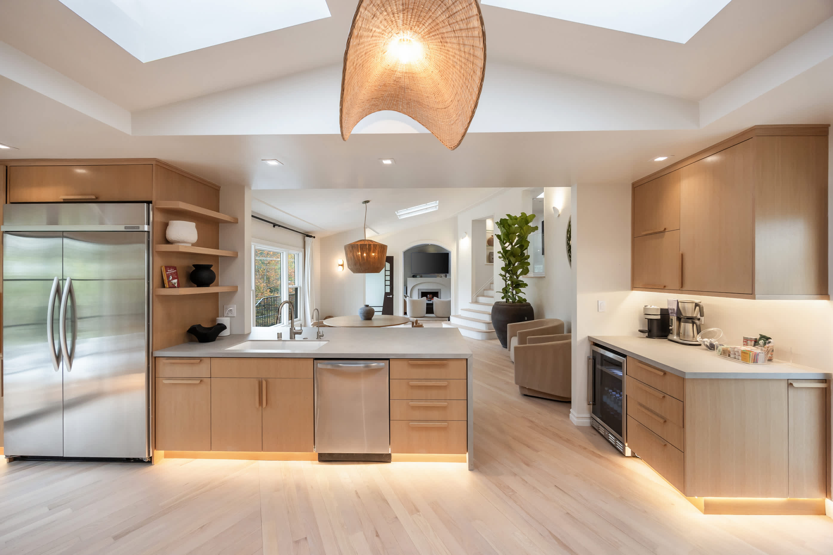 Bright and open kitchen with sleek finishes, soft under-cabinet lighting, and a modern pendant centerpiece.