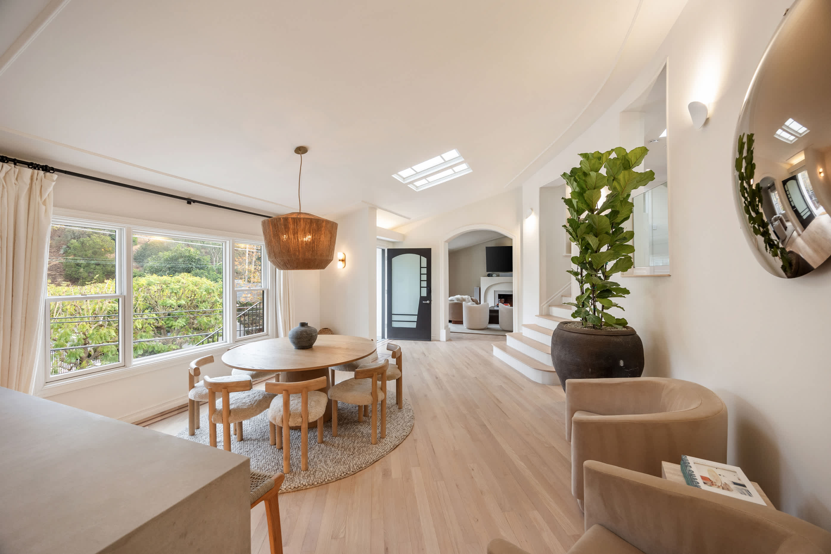 Gather in a sunlit dining area surrounded by natural textures, elegant design, and expansive garden views.