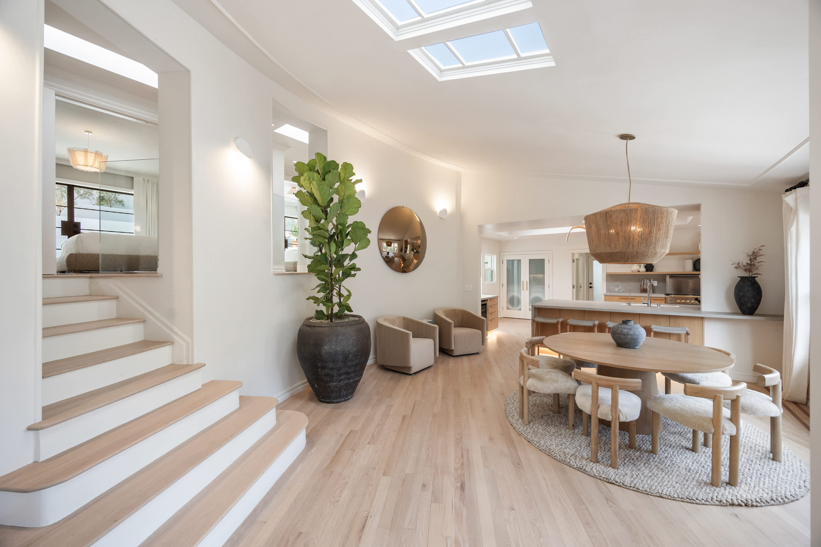Grand stairs lead down to the dining haven rich with natural textures and light.