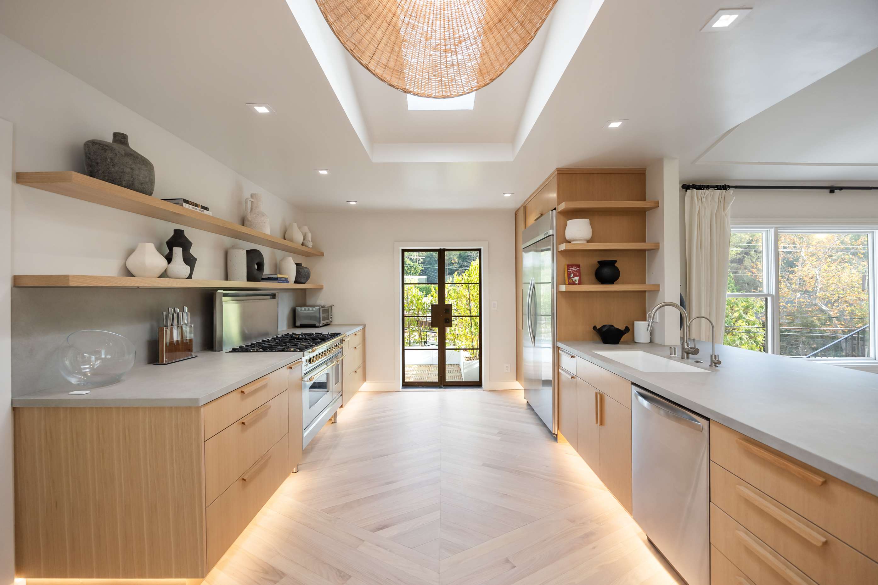 A chef’s dream kitchen with warm wood cabinetry, open shelving, and seamless under-cabinet lighting.