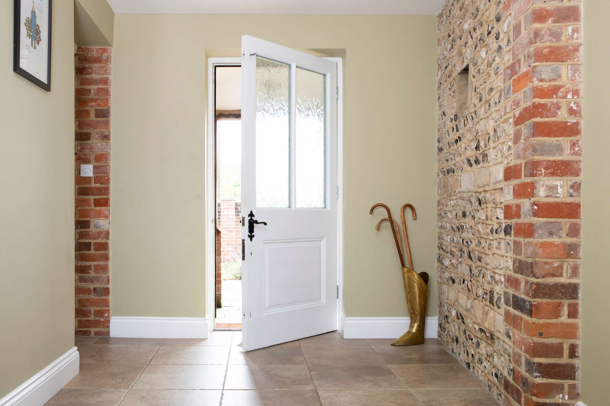 The entrance hall with stunning original brick and flint walls reclaimed from the original barn.