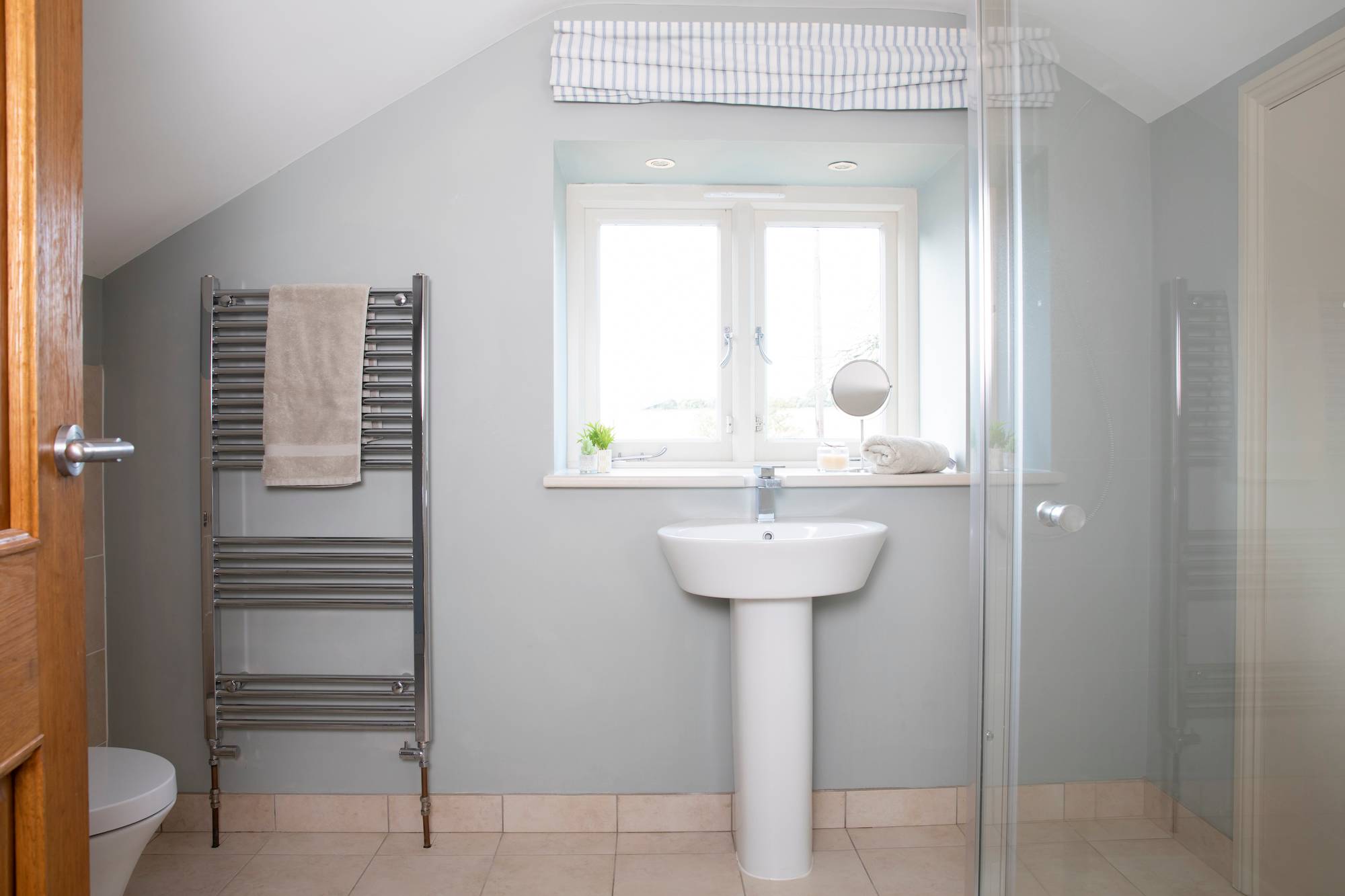 The en suite has a good size walk in shower, basin, toilet and heated towel rail
