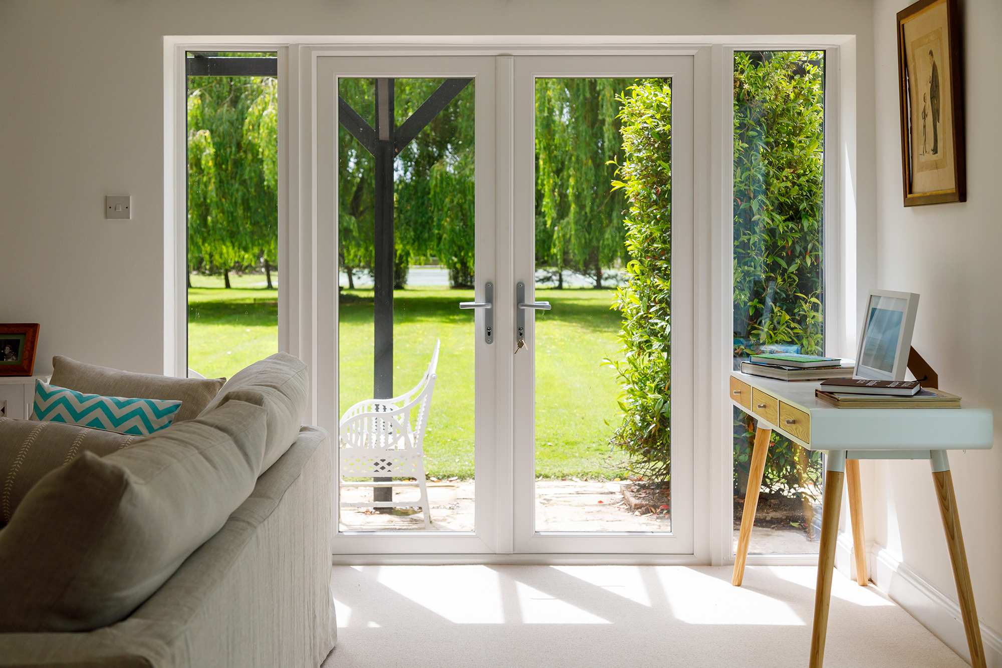 The front lawn has towering willow trees.