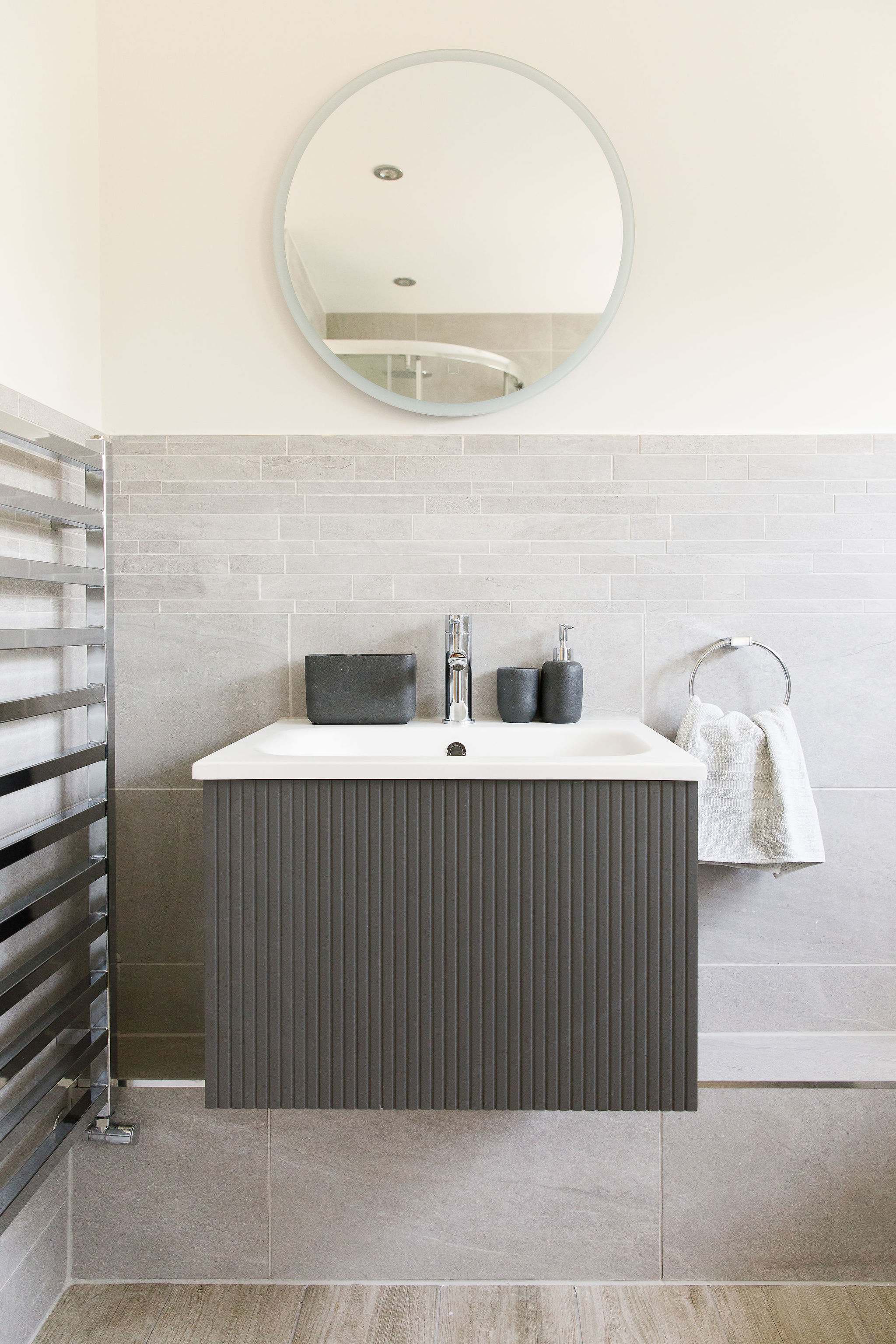 A contemporary sink in the family bathroom with overhead mirror.