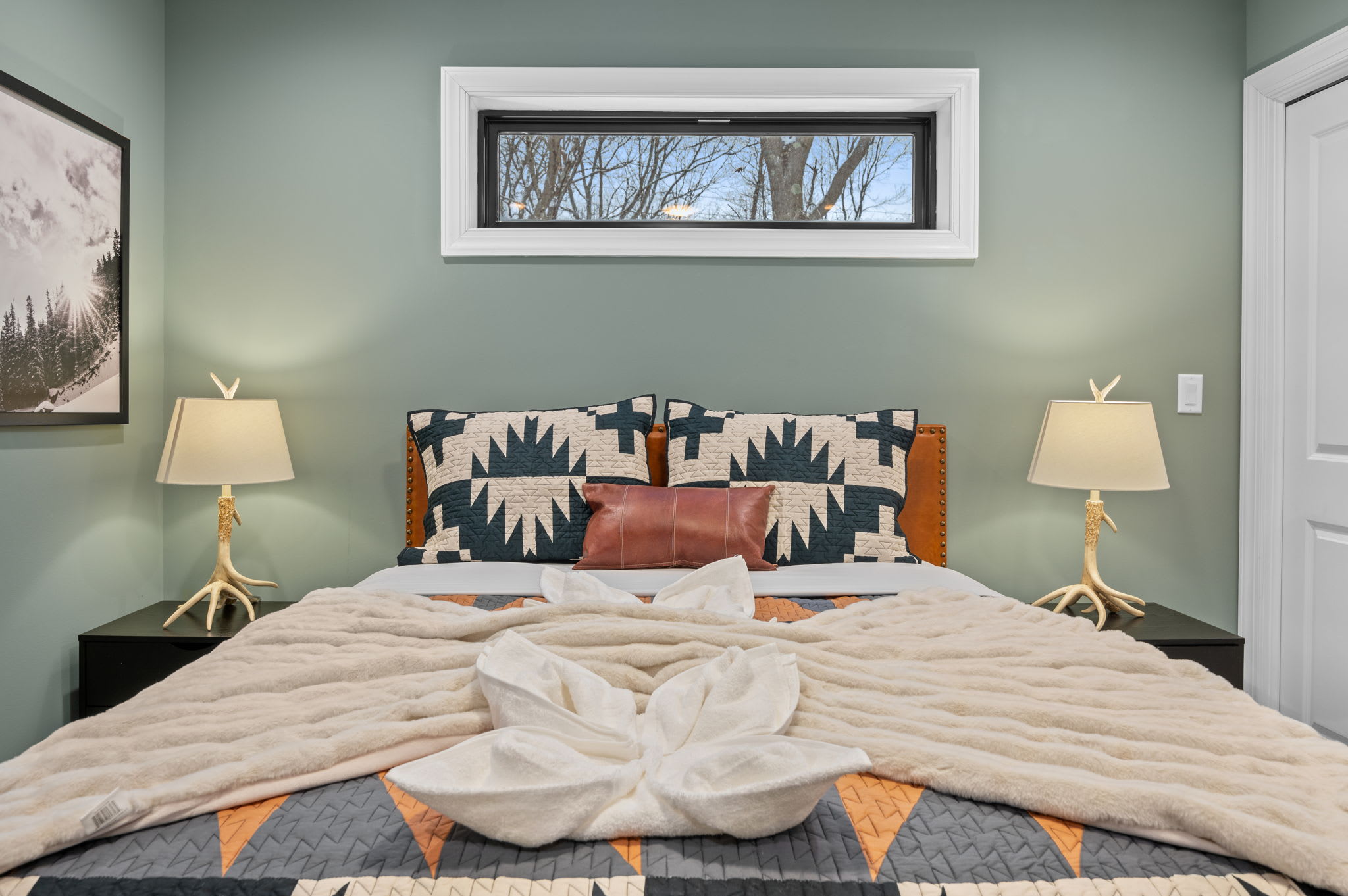 Thoughtful decor, warm lighting, and soft textures make this bedroom a perfect place to recharge.