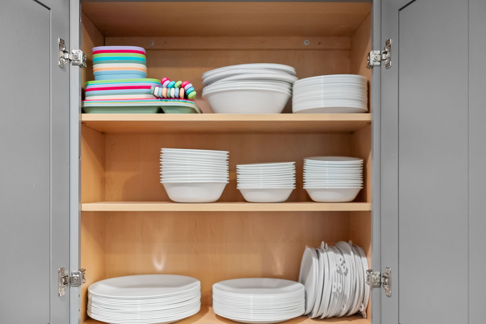 Plenty of dinnerware lines the shelves, including a few colorful pieces for kids or a playful tablescape.