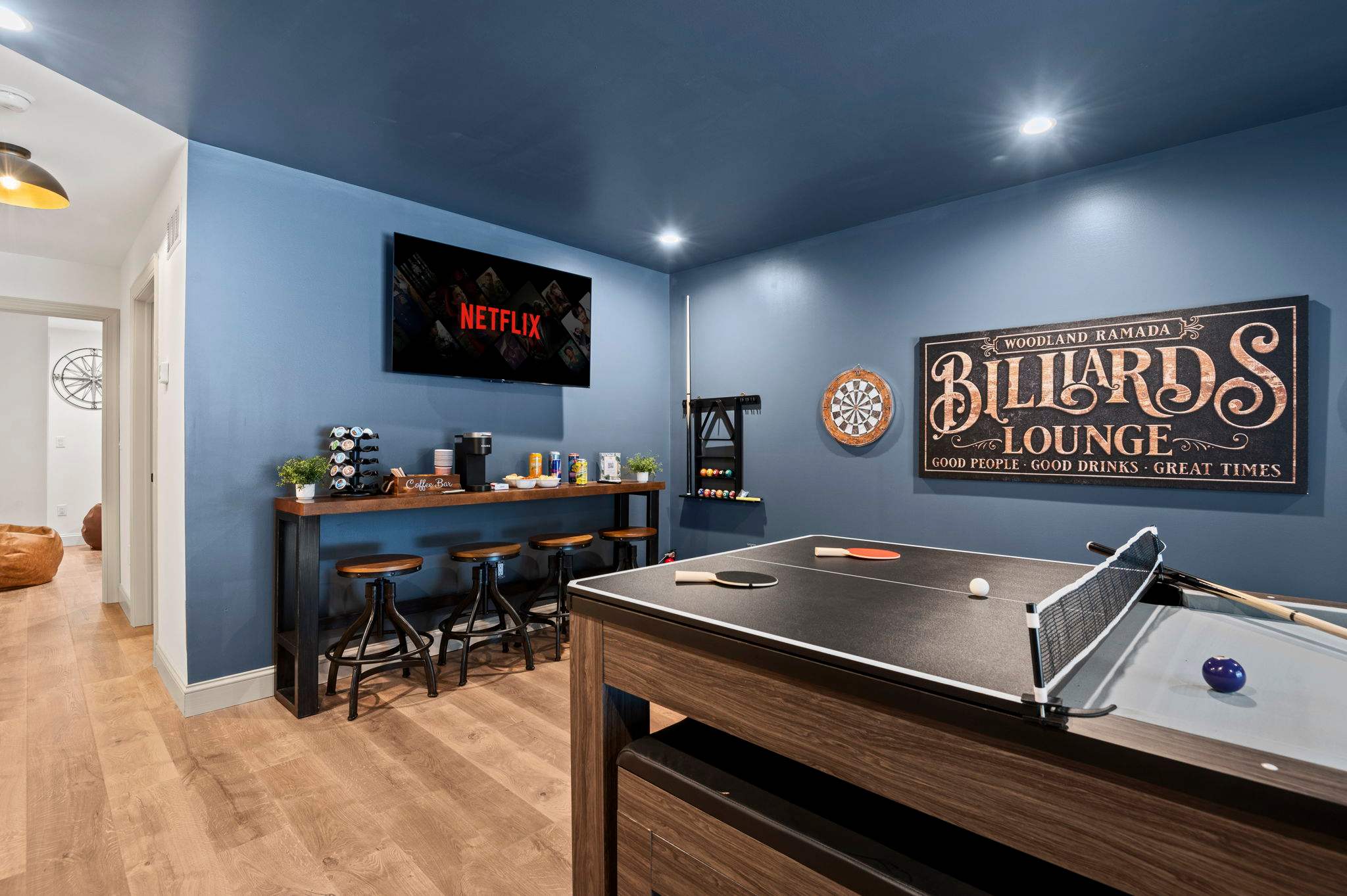 A stylish game room with a pool table, dartboard, and a cozy bar area. Perfect for friendly competitions and unwinding after a long day.