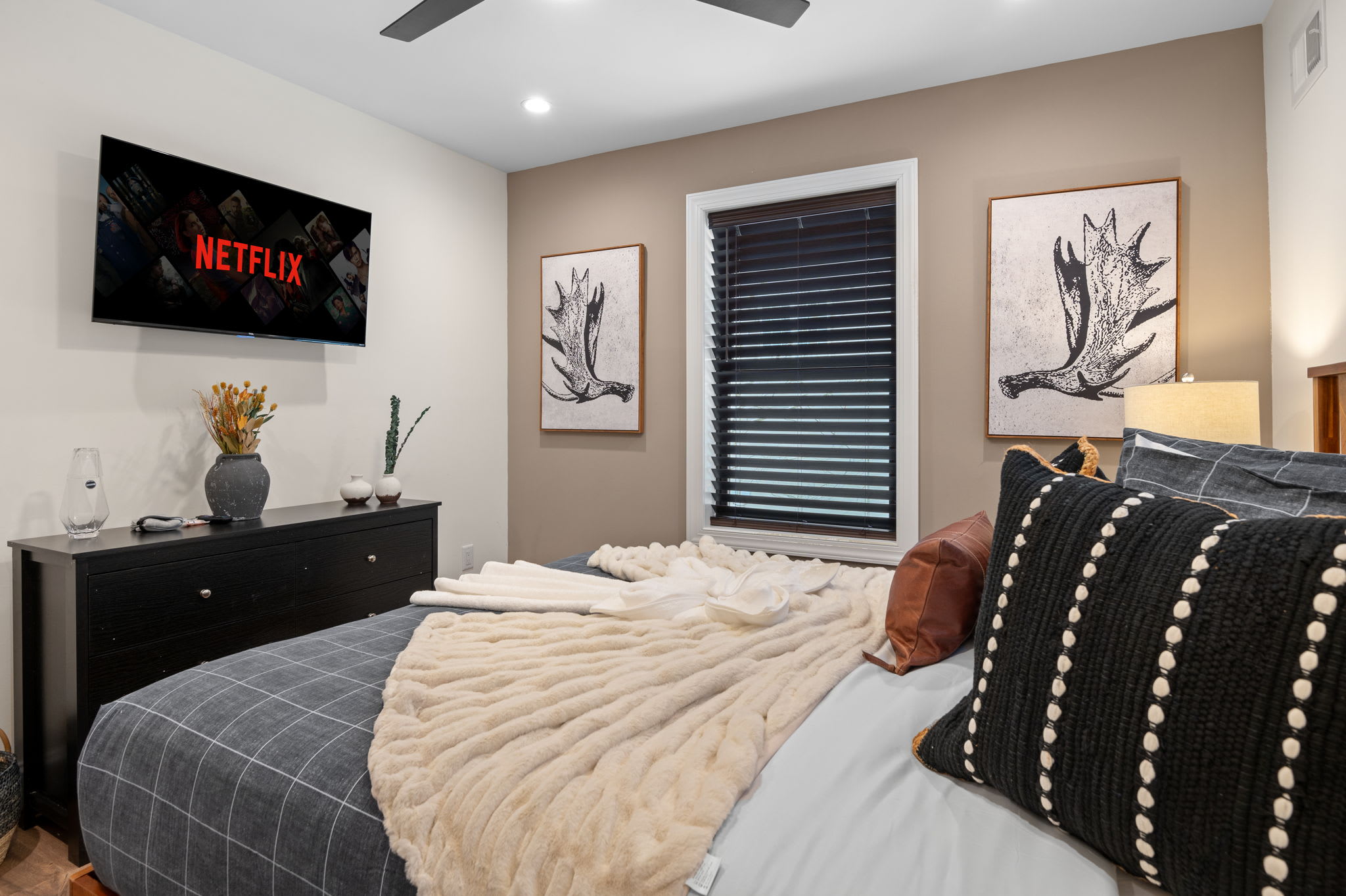 A cozy and stylish space with warm wood tones, plush bedding, and a mounted TV for ultimate relaxation. Perfect for unwinding after a long day.