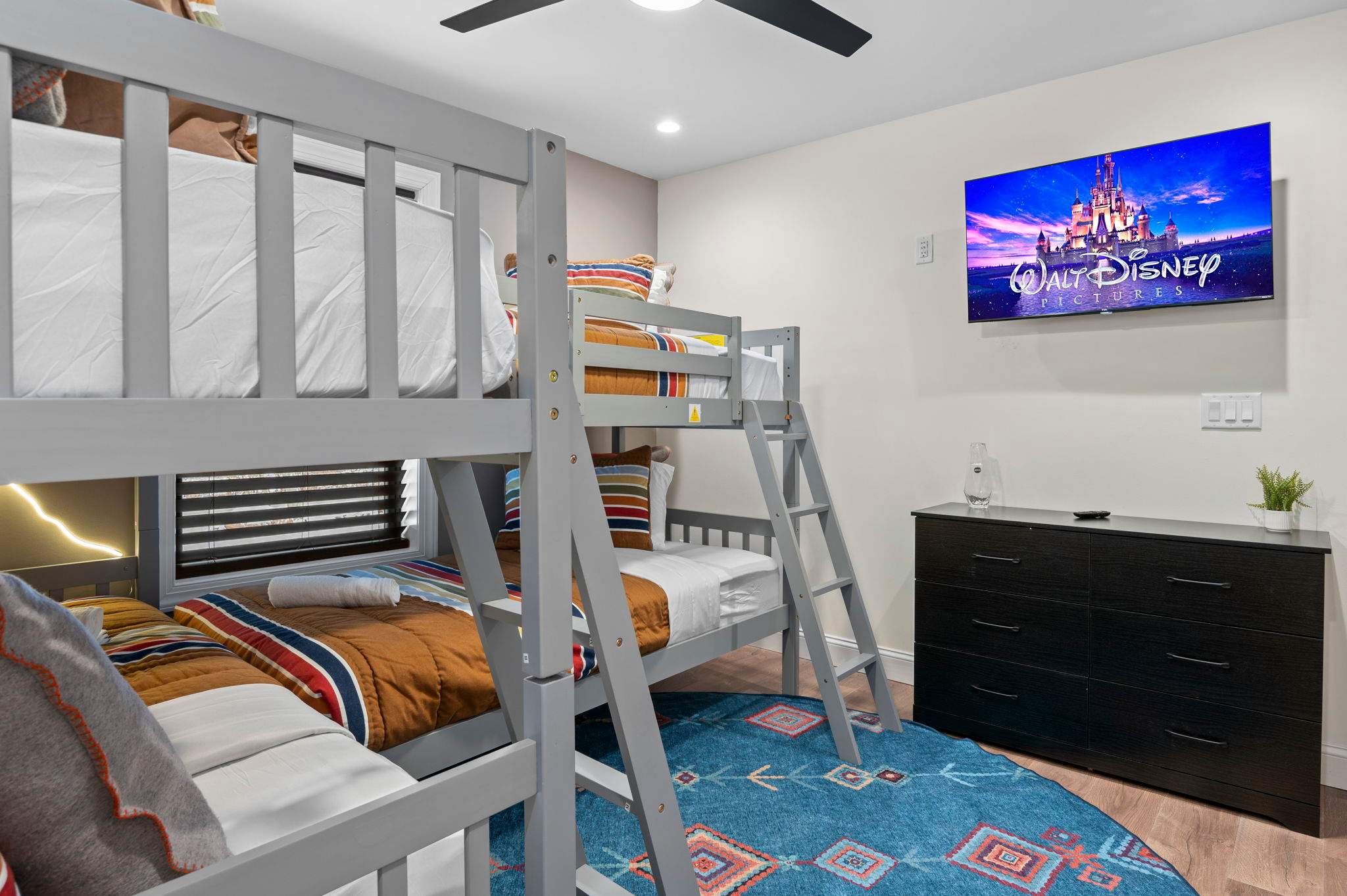 A wall-mounted TV offers instant entertainment in the bunk room, making it a go-to spot for movie nights or cartoon marathons.