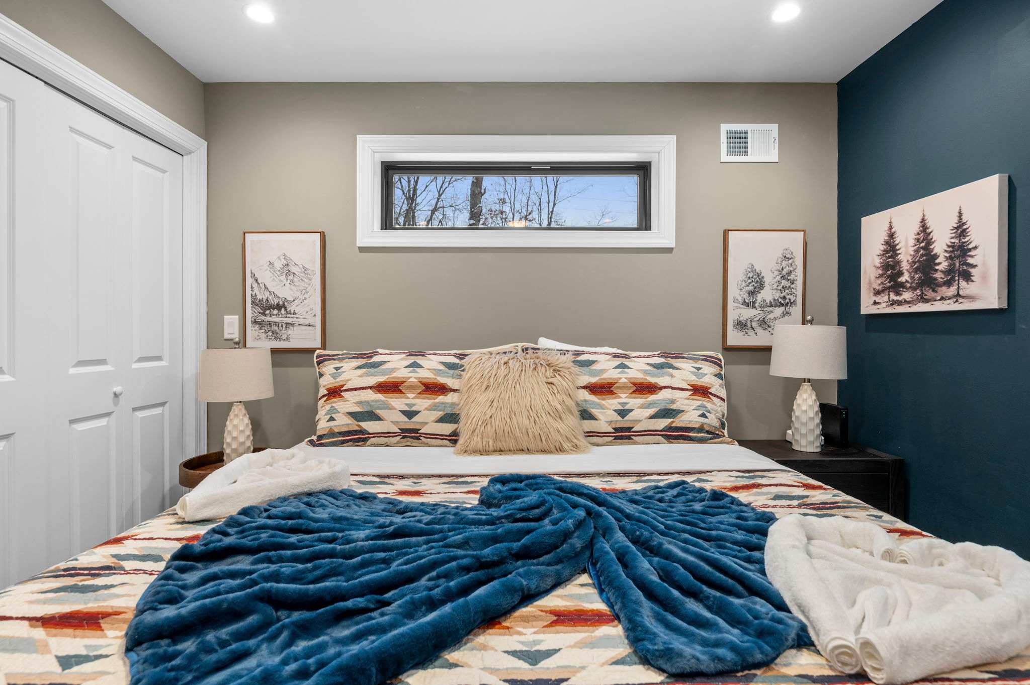 A closer look reveals the cozy king bed, plush throws, and a picture window that fills the room with natural light.