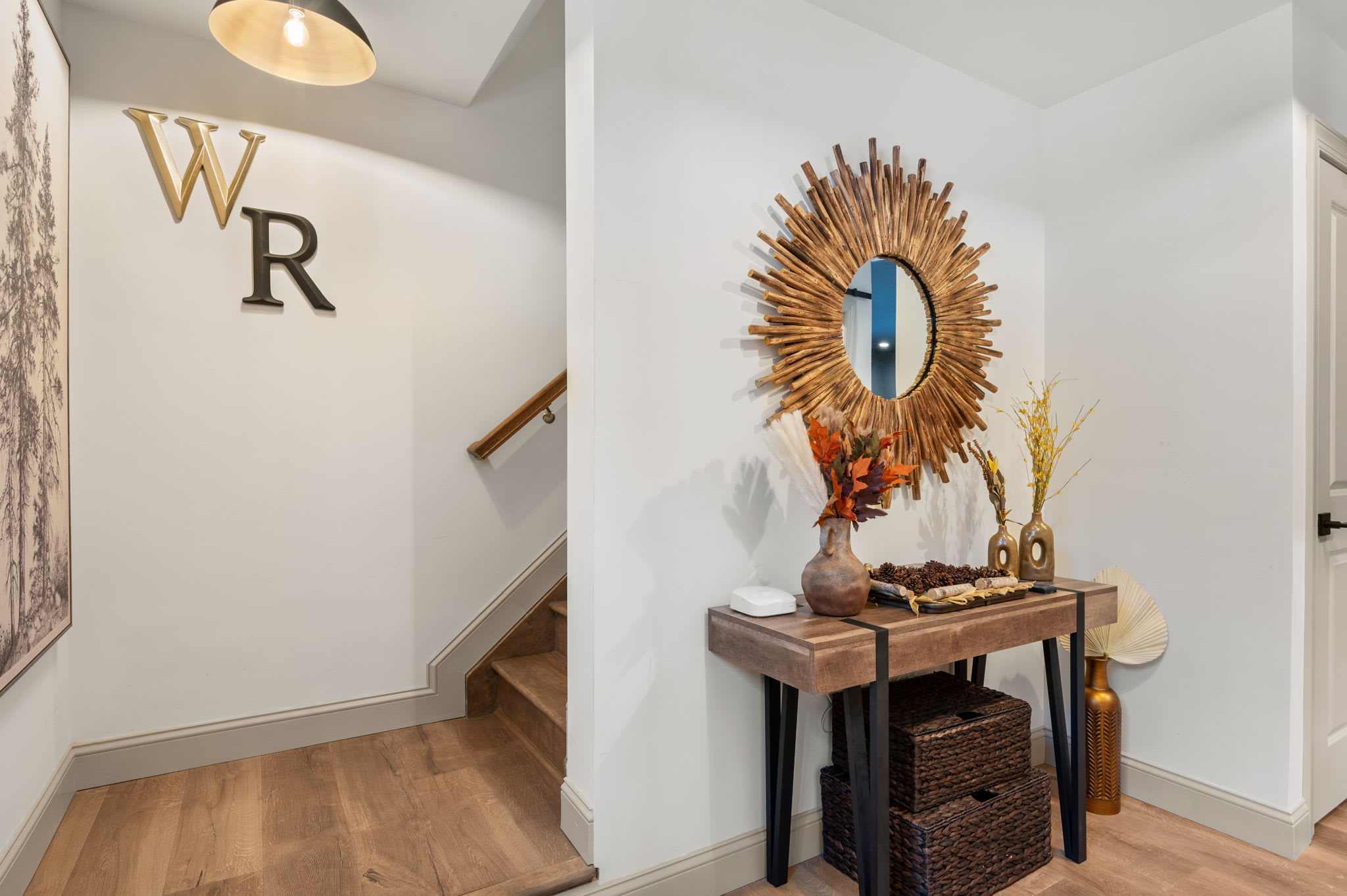 A closer look down the hall reveals a sleek staircase and subtle personal touches, seamlessly guiding you through the home’s relaxed, inviting atmosphere.