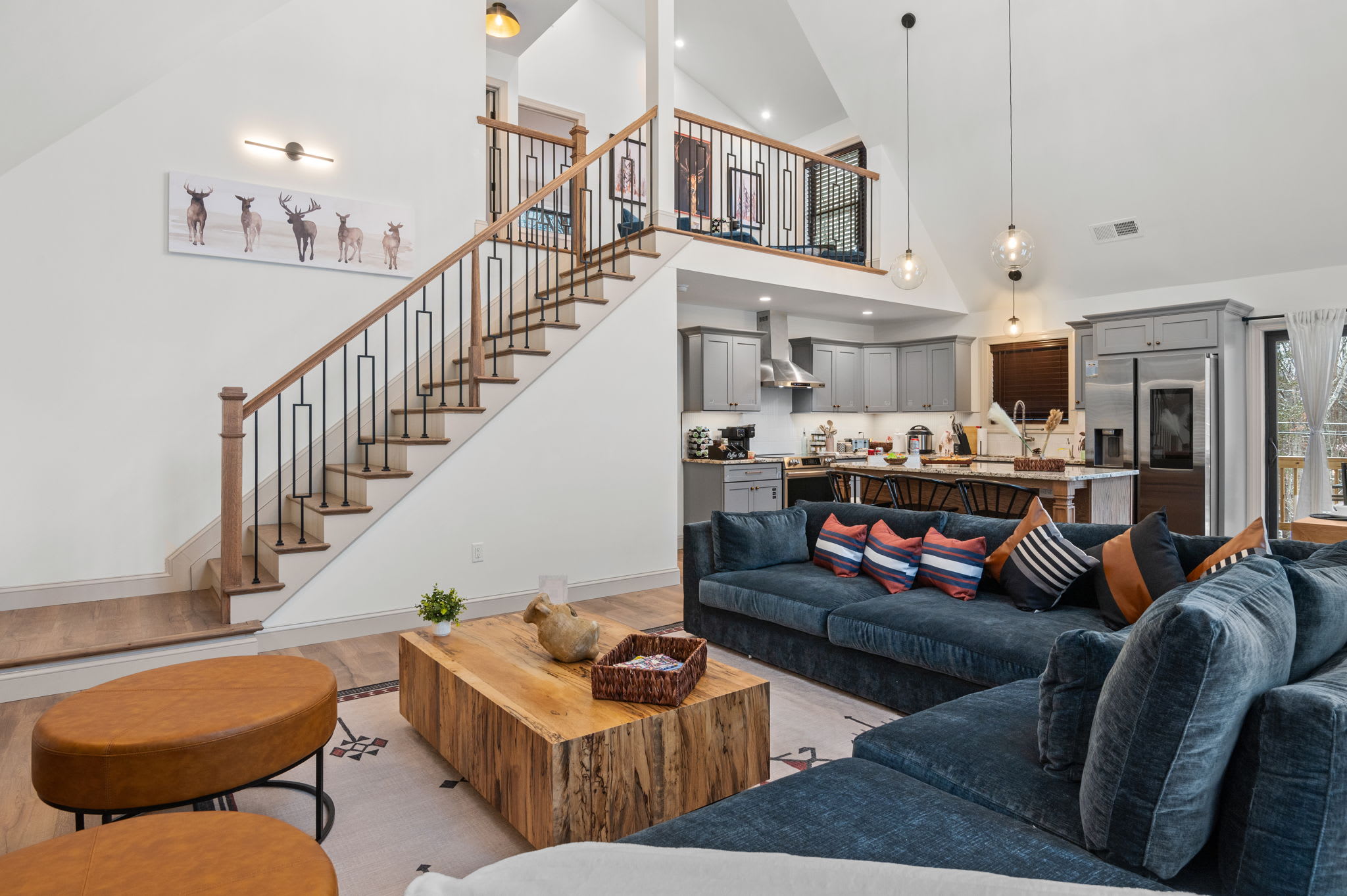From this angle, the spacious layout ties together the living room, kitchen, and dining area, showcasing the inviting sectional and warm wood accents.