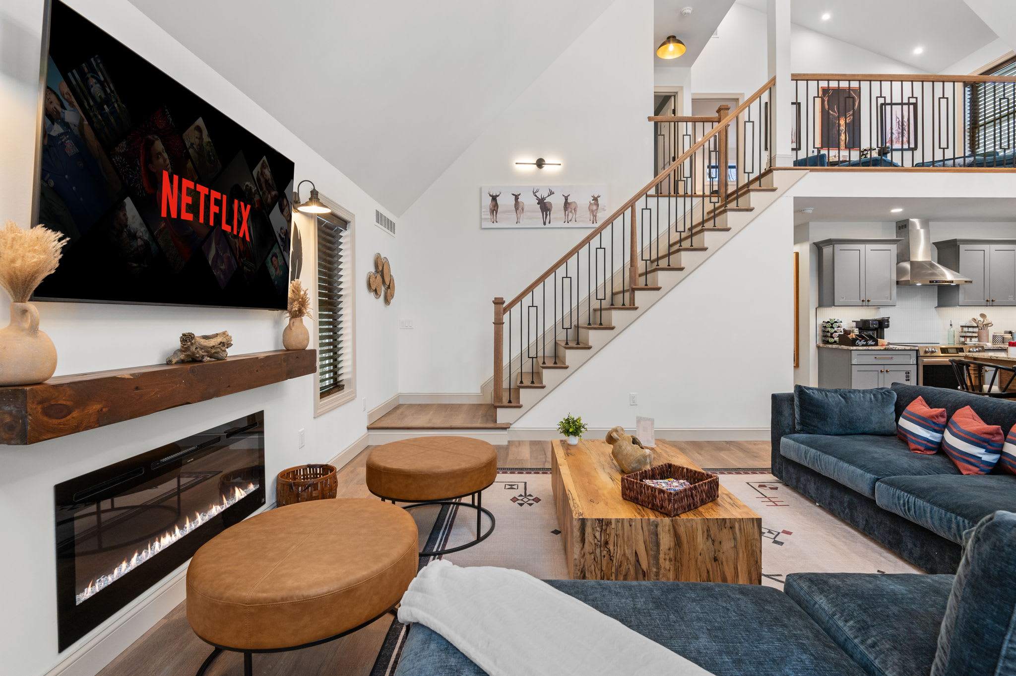 High ceilings, a grand staircase, and a cozy fireplace set the tone in this open-concept living area, perfect for movie nights or relaxed conversation.