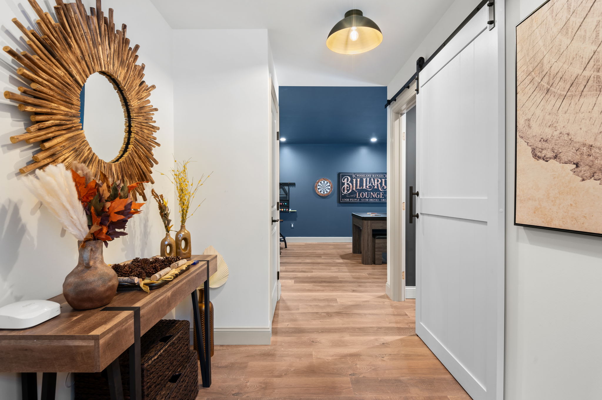 Sliding barn doors open to the living room, the ‘Billiards Lounge’ sign and playful artwork promise plenty of fun beyond the entryway.