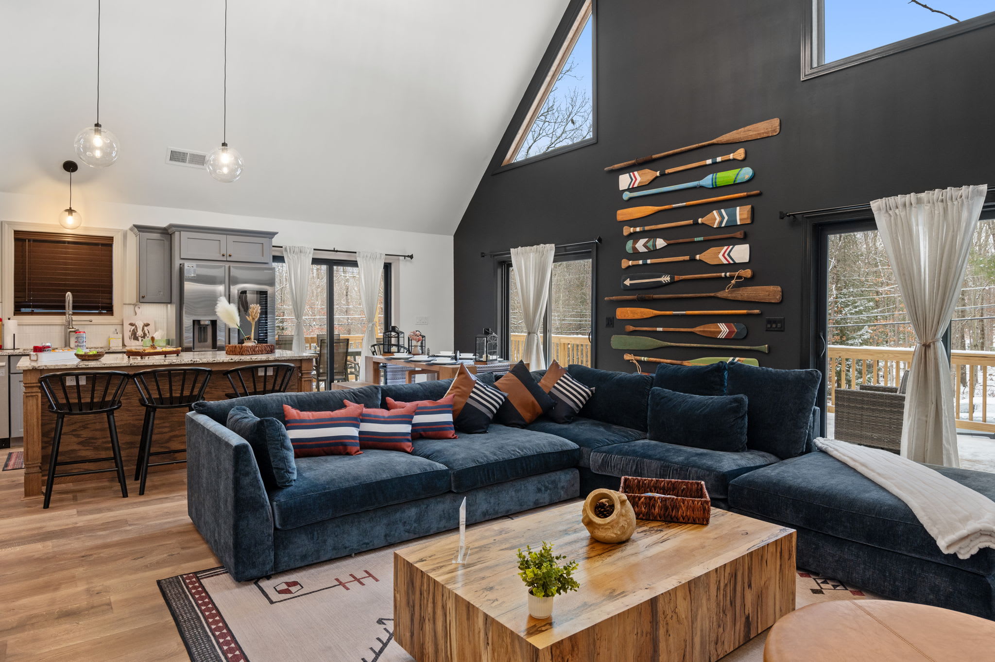 Rustic paddles on the wall add a fun, outdoorsy flair to the vaulted space, balanced by modern furnishings that encourage everyone to gather.