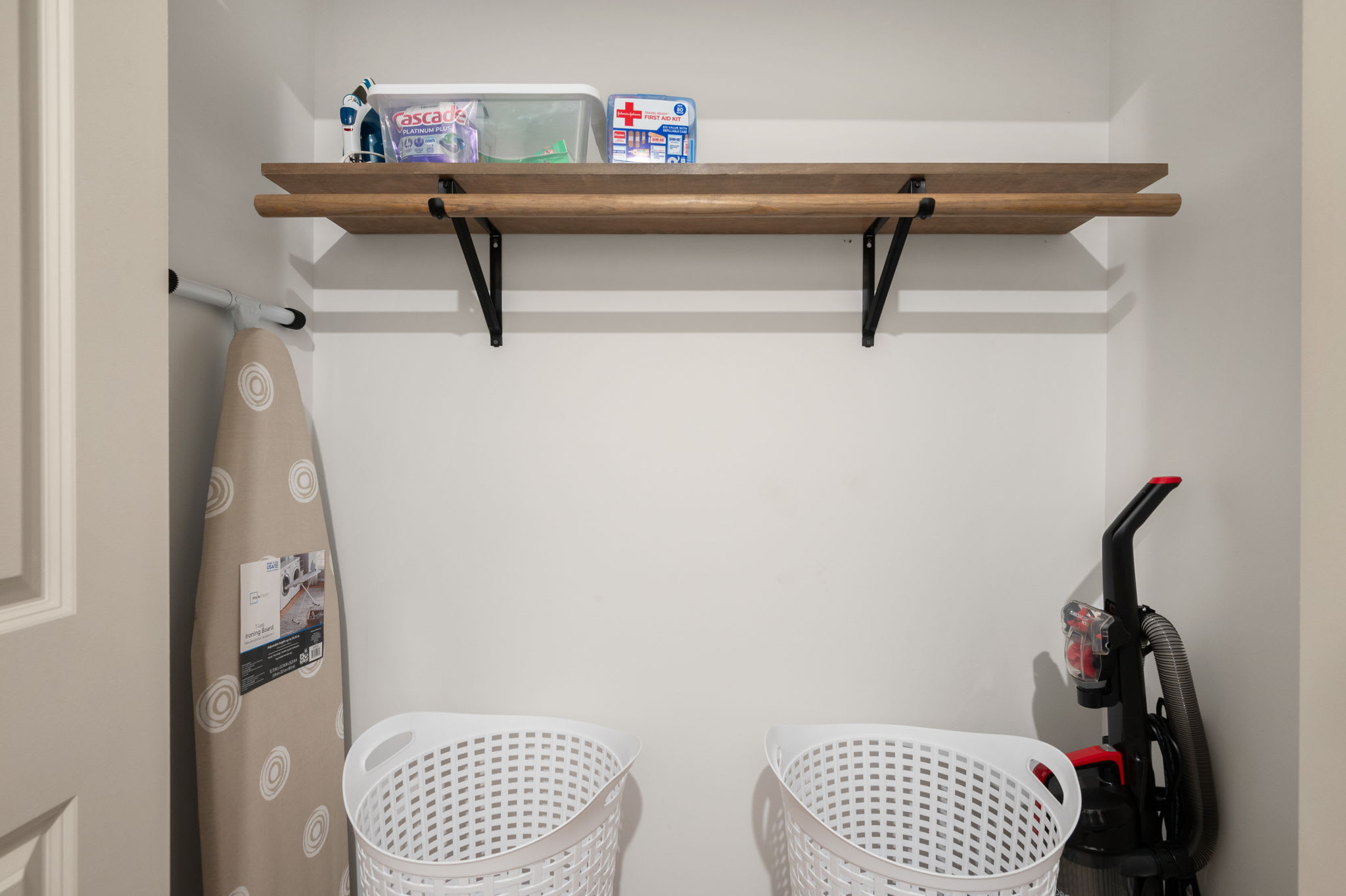 Stay organized with a fully stocked laundry closet, complete with an ironing board, extra baskets, and even a first aid kit for peace of mind.