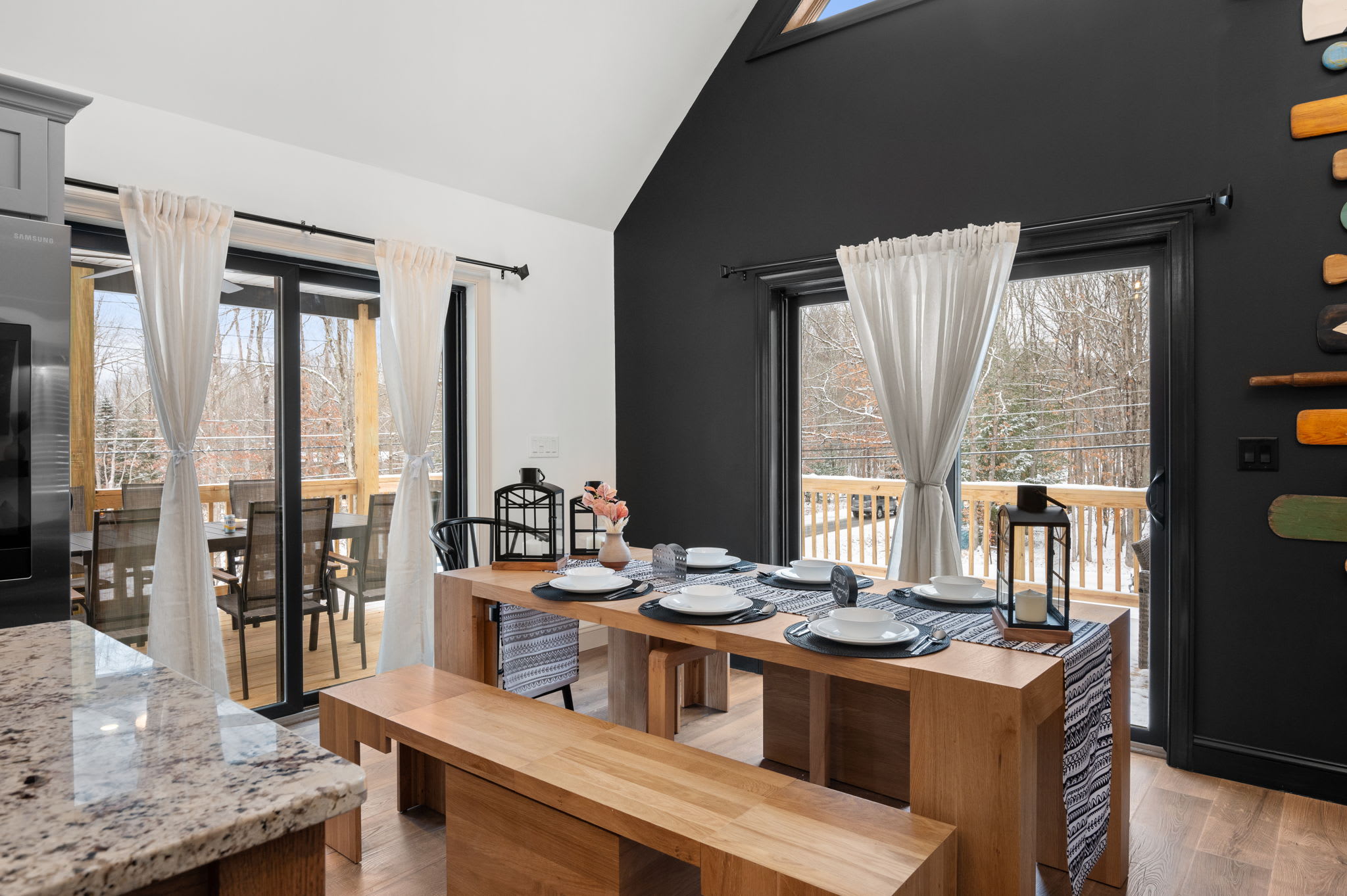 The dining area opens up to the deck, with a warm wood table and bench seating that invites everyone to linger over meals.