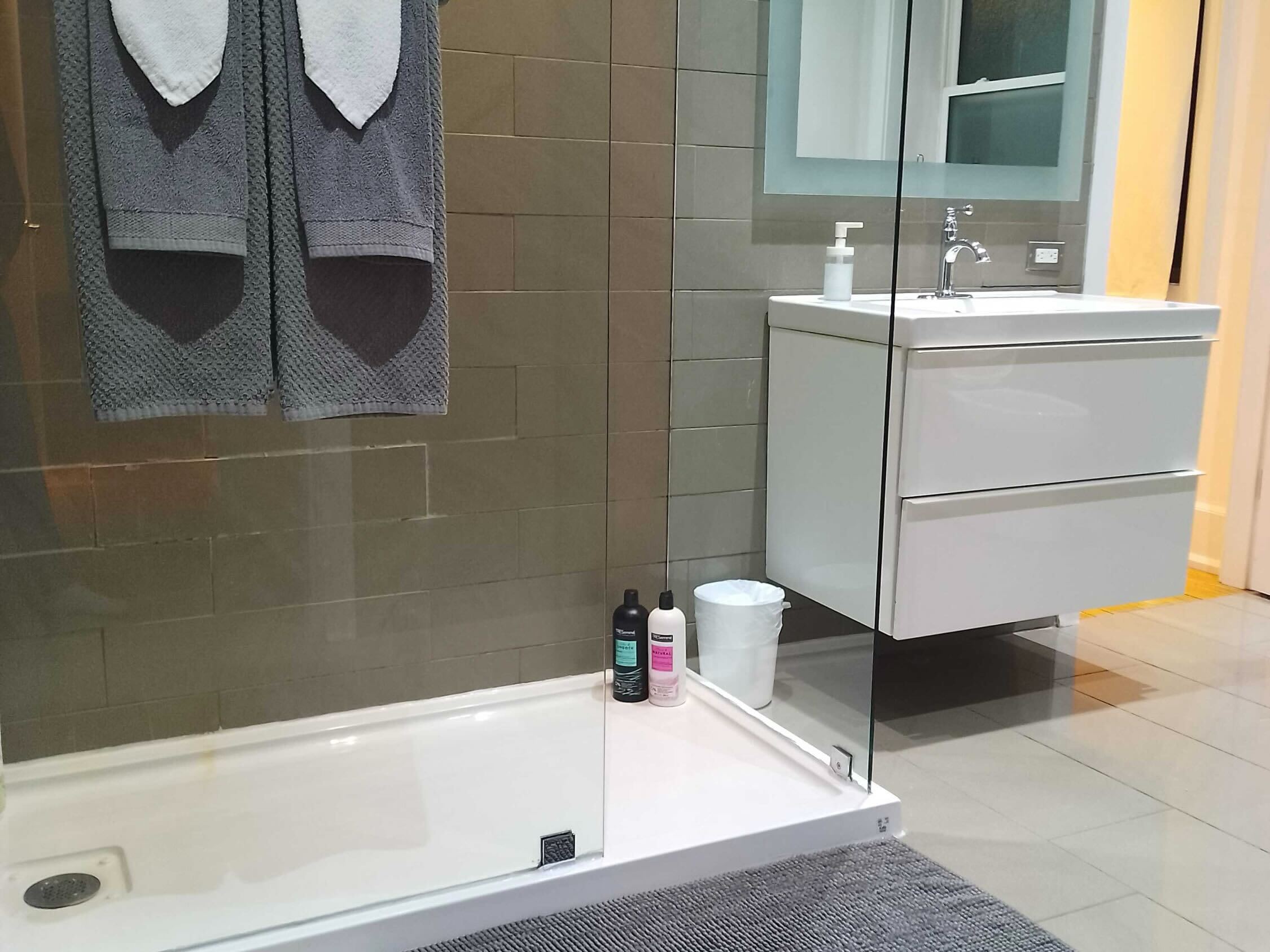 Sleek Bathroom With Glass-Enclosed Walk-In Shower And Contemporary Vanity