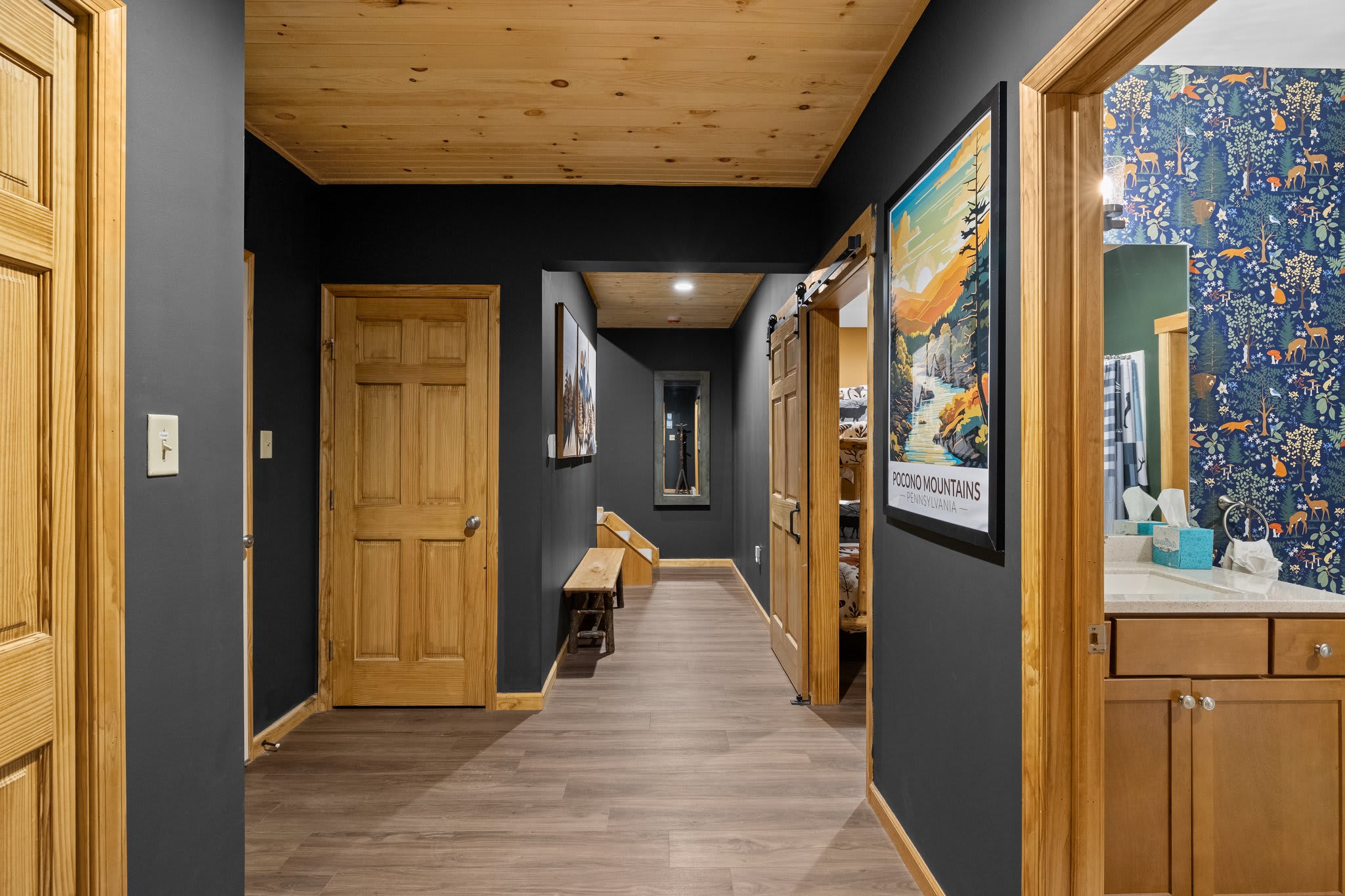 Hallway with Character
A warm, wood-toned hallway lined with bold art gives this lake house its signature style and charm.