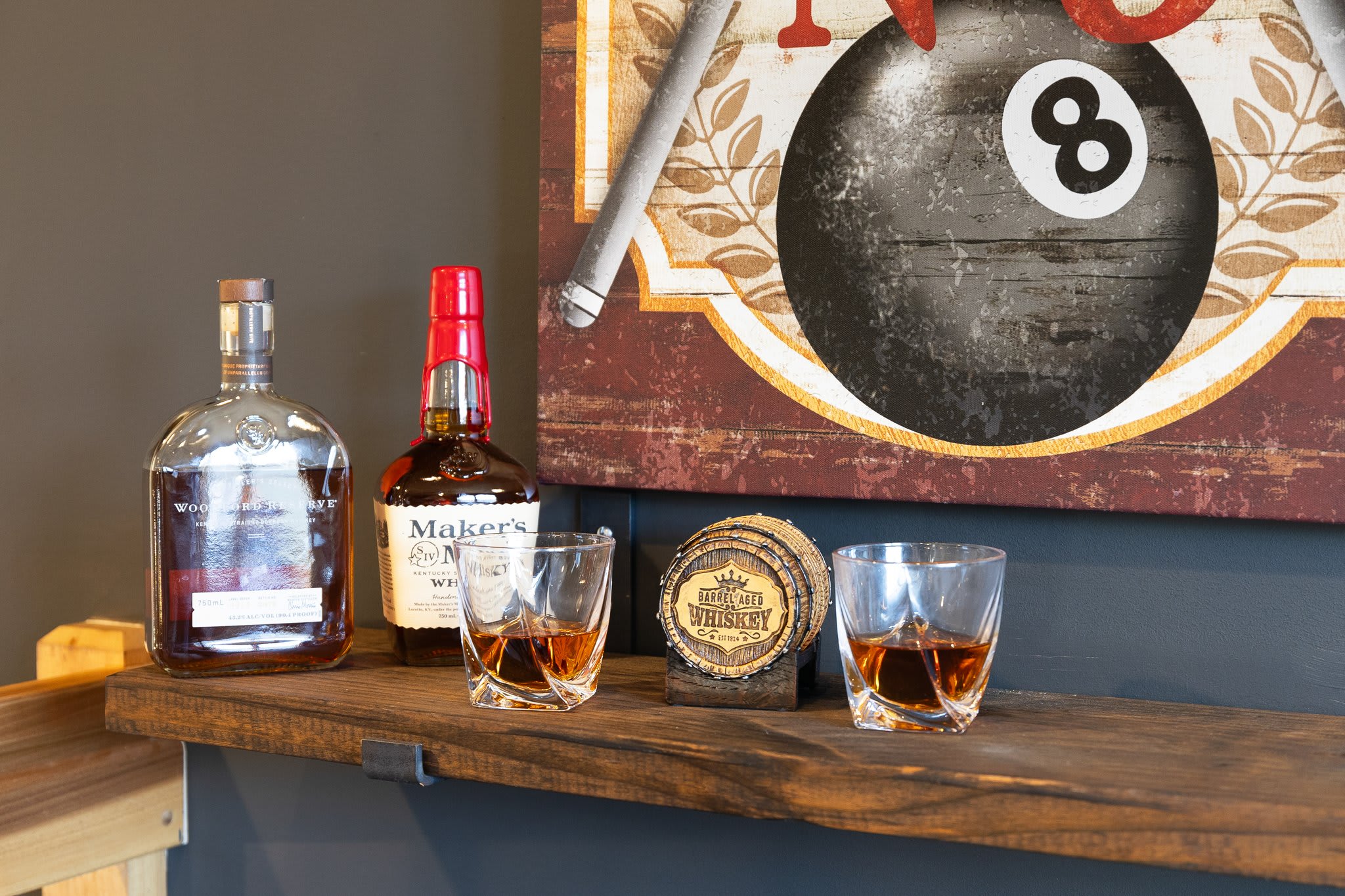 Whiskey on display with two glasses and rustic textures, definitely where conversations begin.