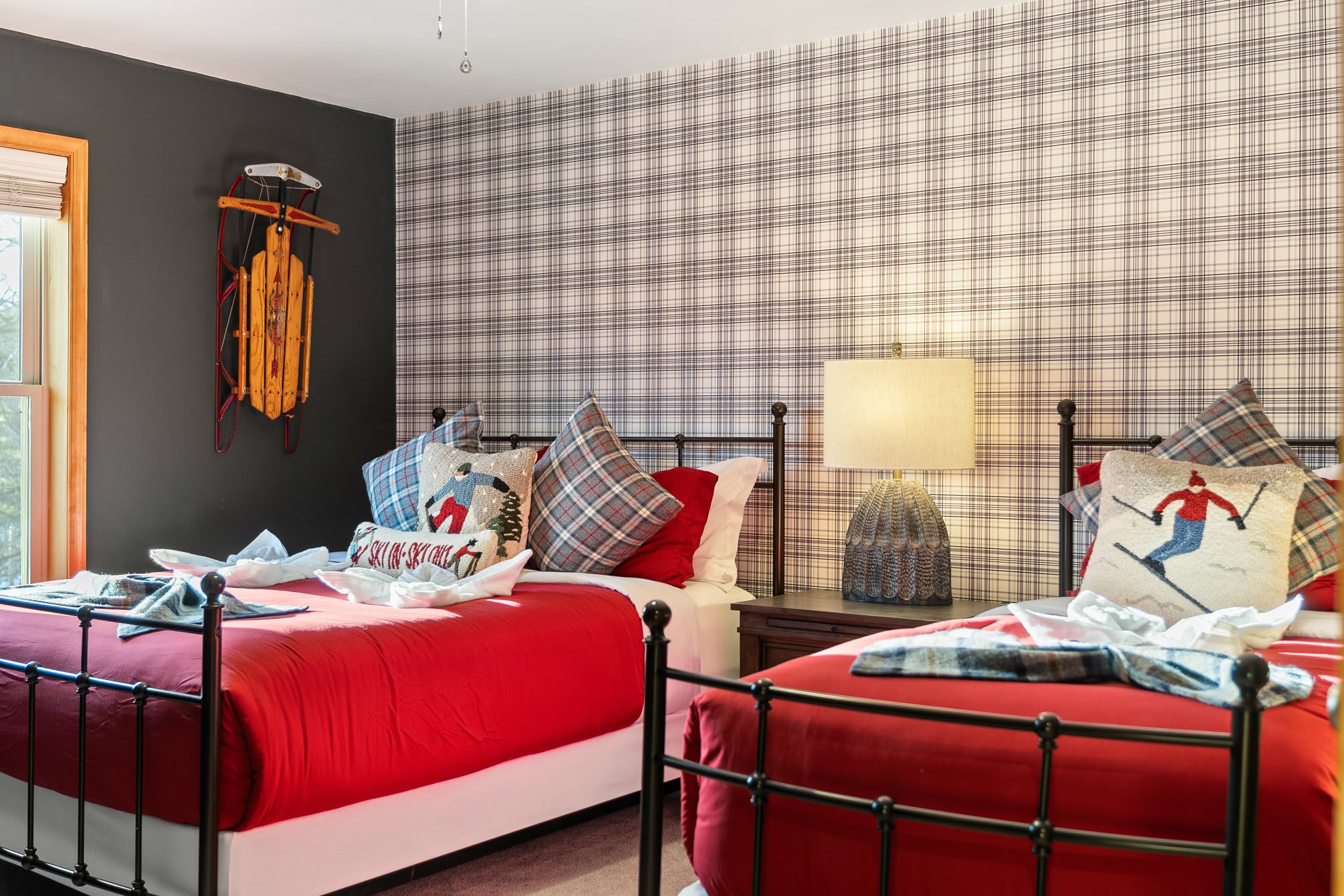 Matching beds framed by playful ski-themed decor and wall-to-wall plaid, it’s pure winter-lodge energy.