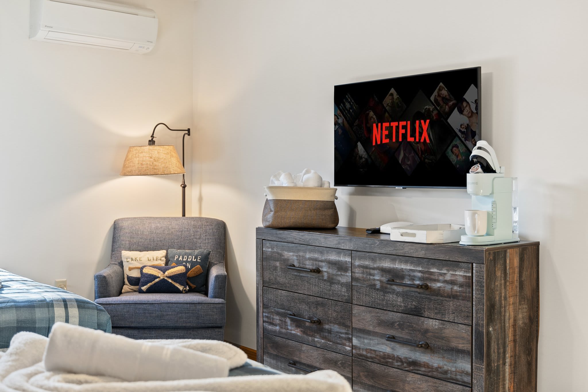 Simple and serene with a mounted TV and a comfy chair setup, this corner is perfect for winding down.