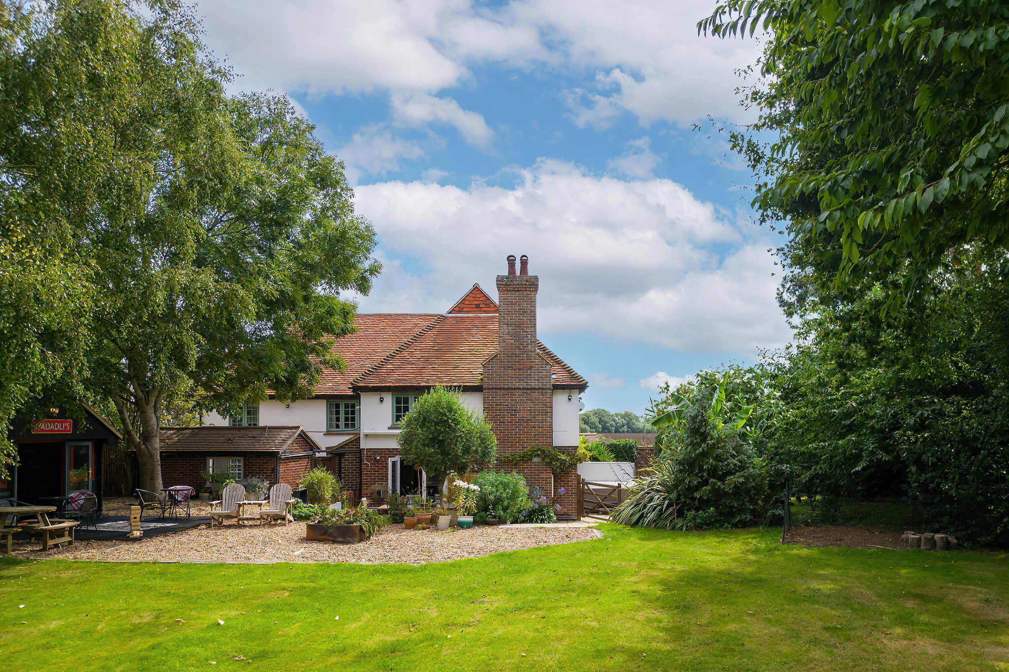 Lush lawns and trees surround the home.