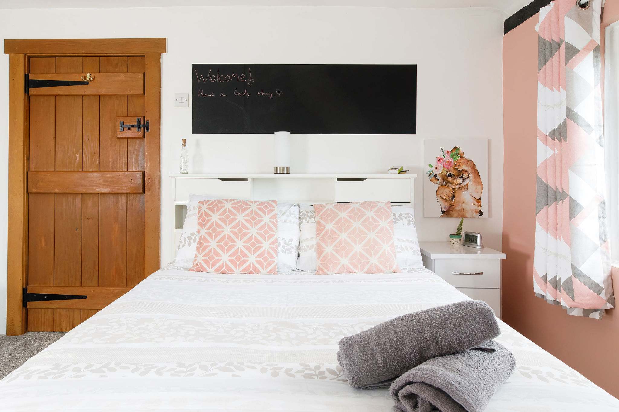 This bedroom is decorated in soft pinks and greys.