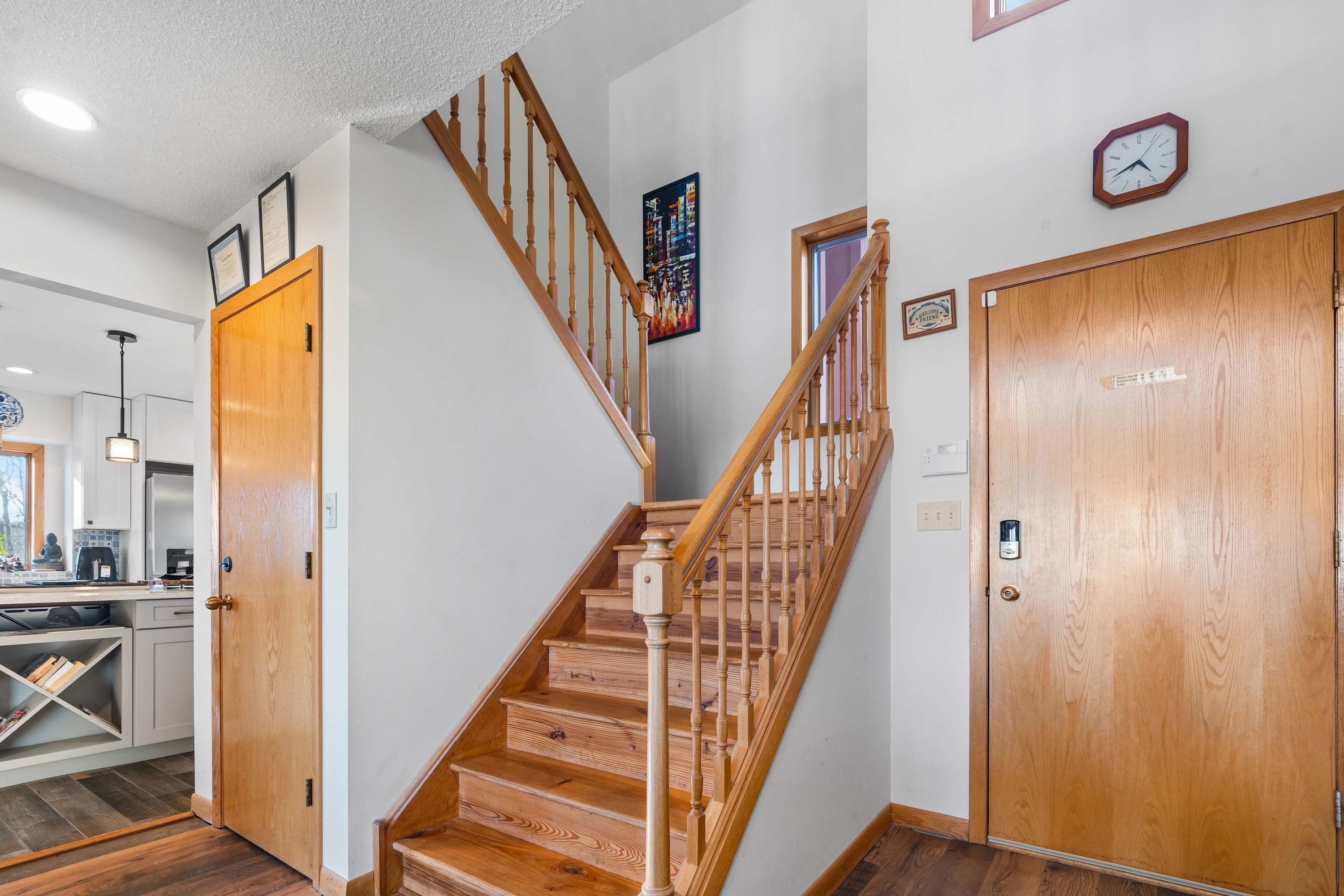 The natural wood tones of the staircase and doors add such a warm and rustic charm to the space! Plus, that keyless entry on the front door is a nice modern touch for convenience. 