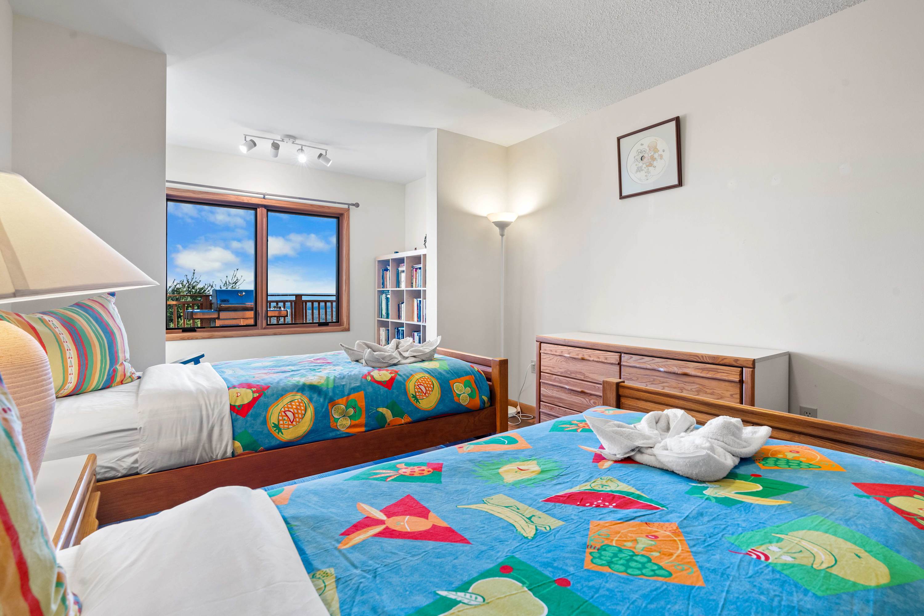 Two cozy single beds, playful bedding, and a stunning view, perfect for a restful escape.