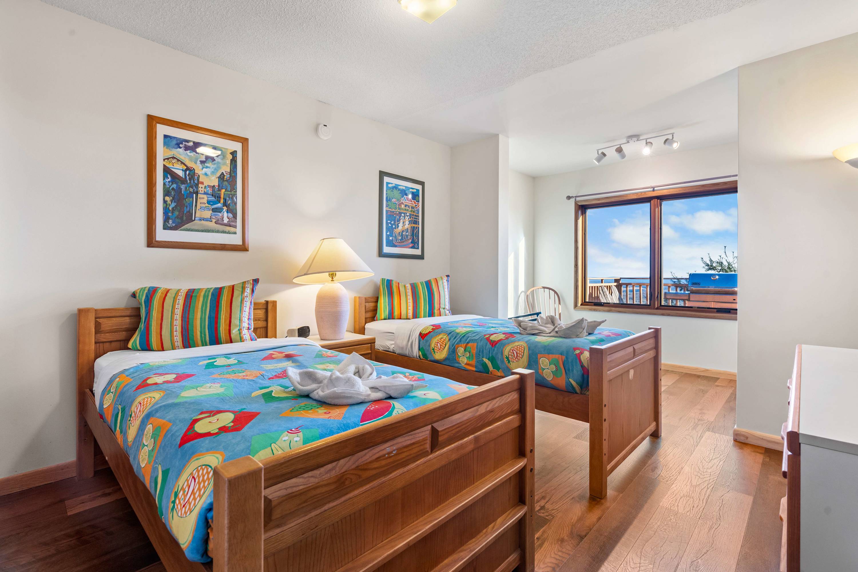 Two comfy single beds, vibrant linens, and a stunning view, your cozy mountain escape.