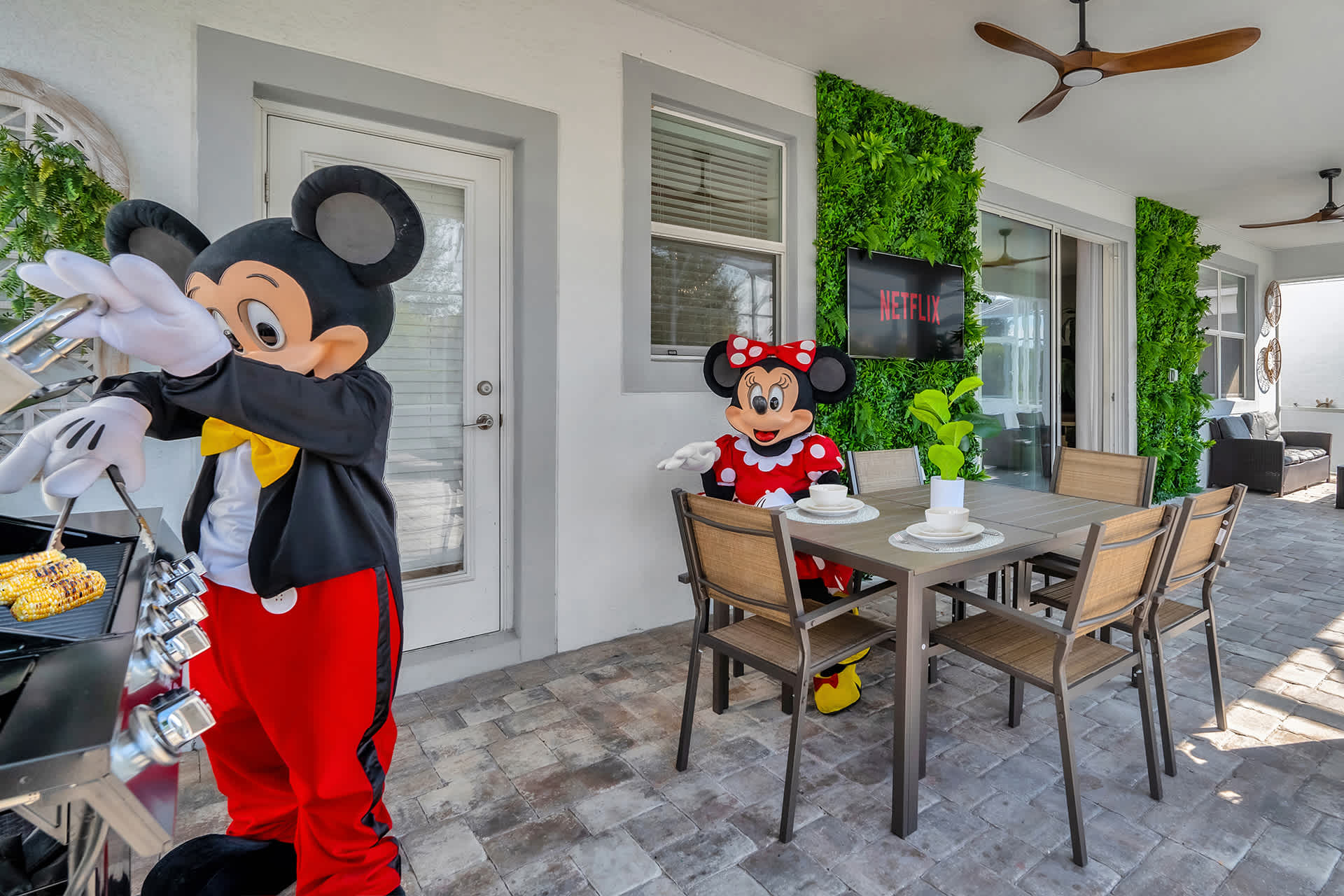 BBQ Grill and Outdoor Dining Area with Wall-Mounted Smart TV