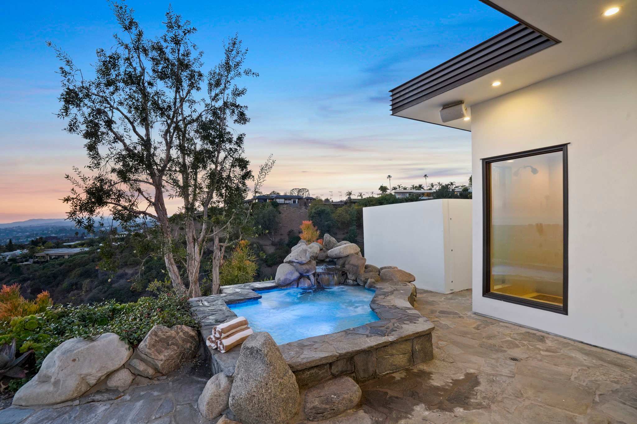 Soak in relaxation surrounded by stone accents and breathtaking city views.