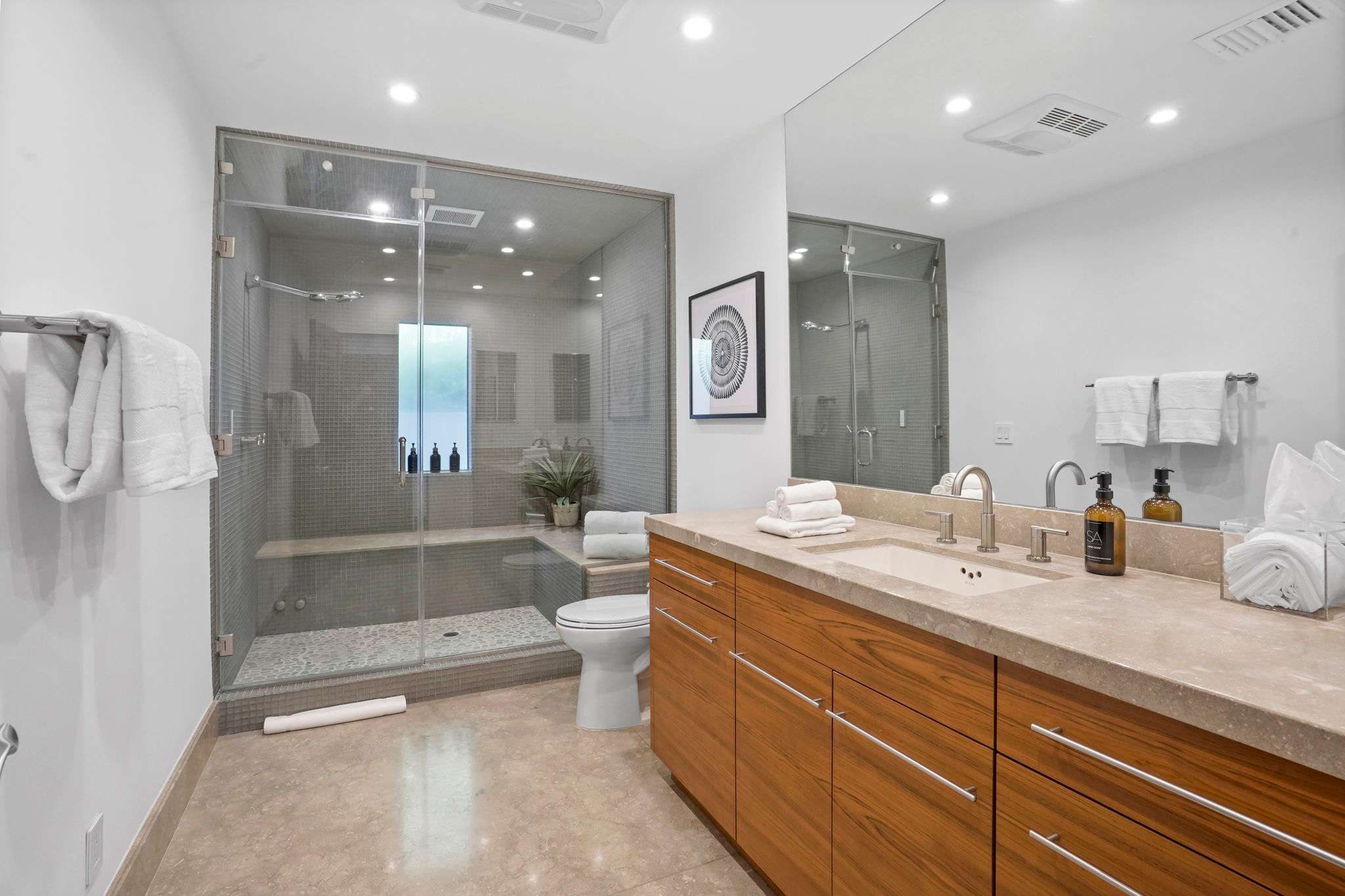 Indulge in the walk-in glass shower, accented by modern tiles and sleek fixtures.