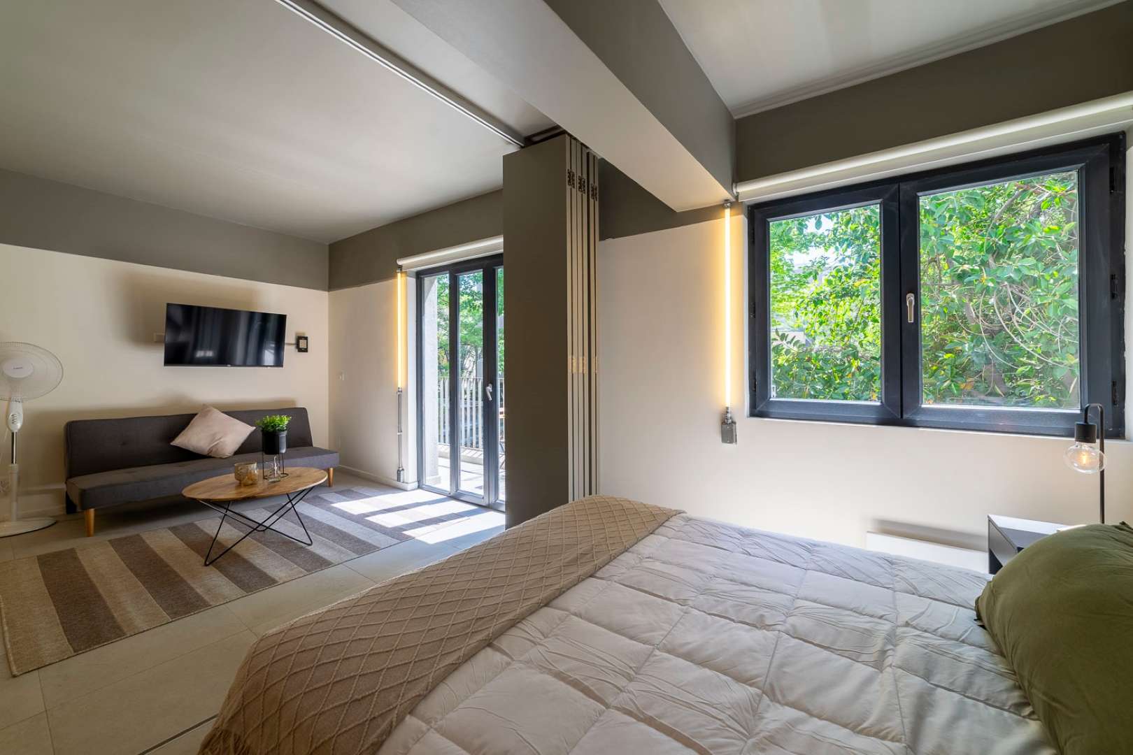 Relax in this serene studio with natural light and garden views, perfect for unwinding after a day of exploring.