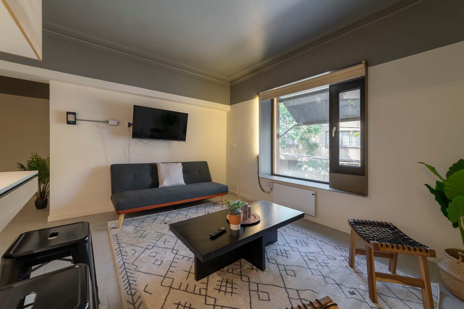 Relax in a stylish living area with a cozy sofa, modern decor, and serene views through a large window.