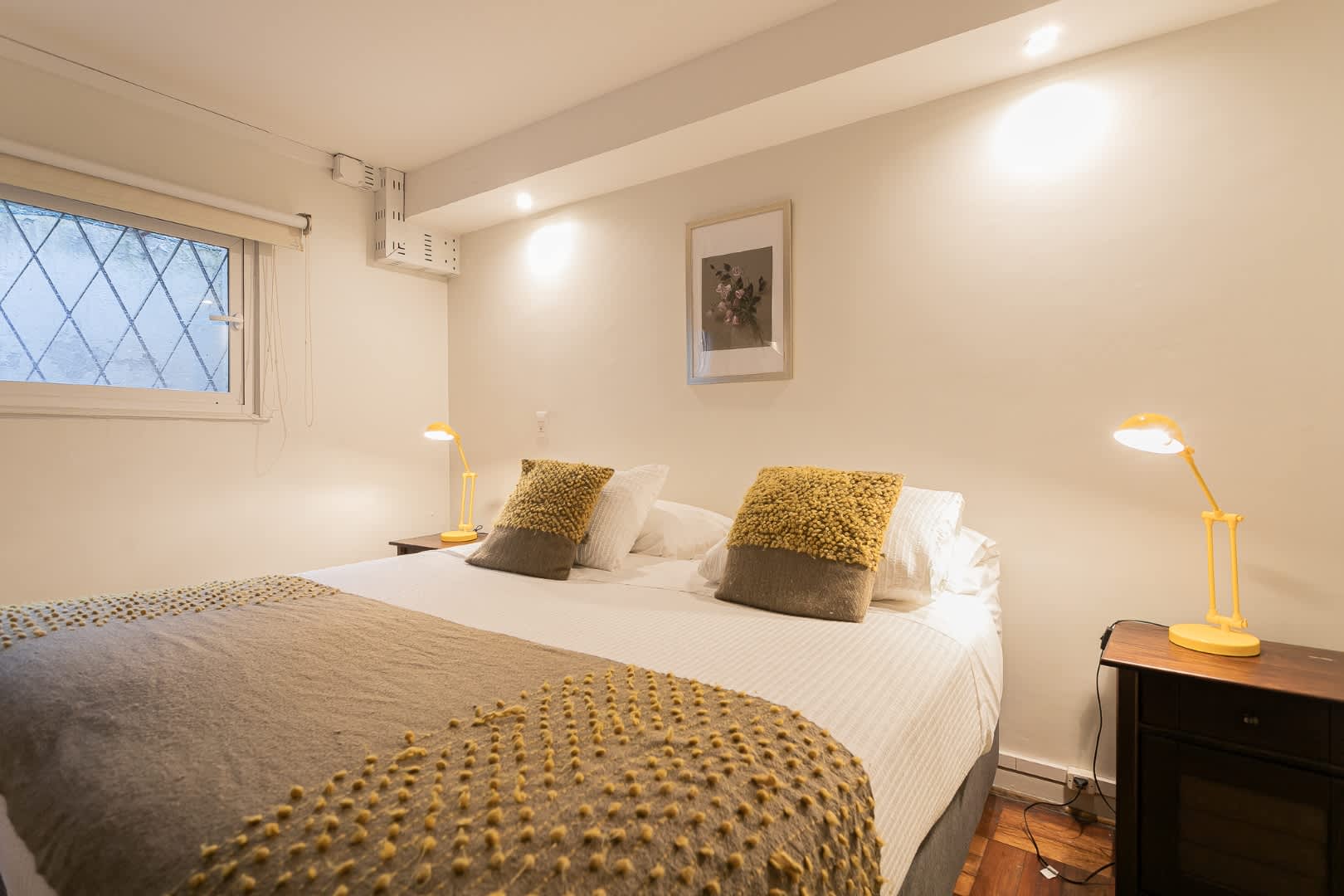 Relax in this cozy bedroom with a plush bed, stylish decor, and warm lighting, perfect for a restful night's sleep.