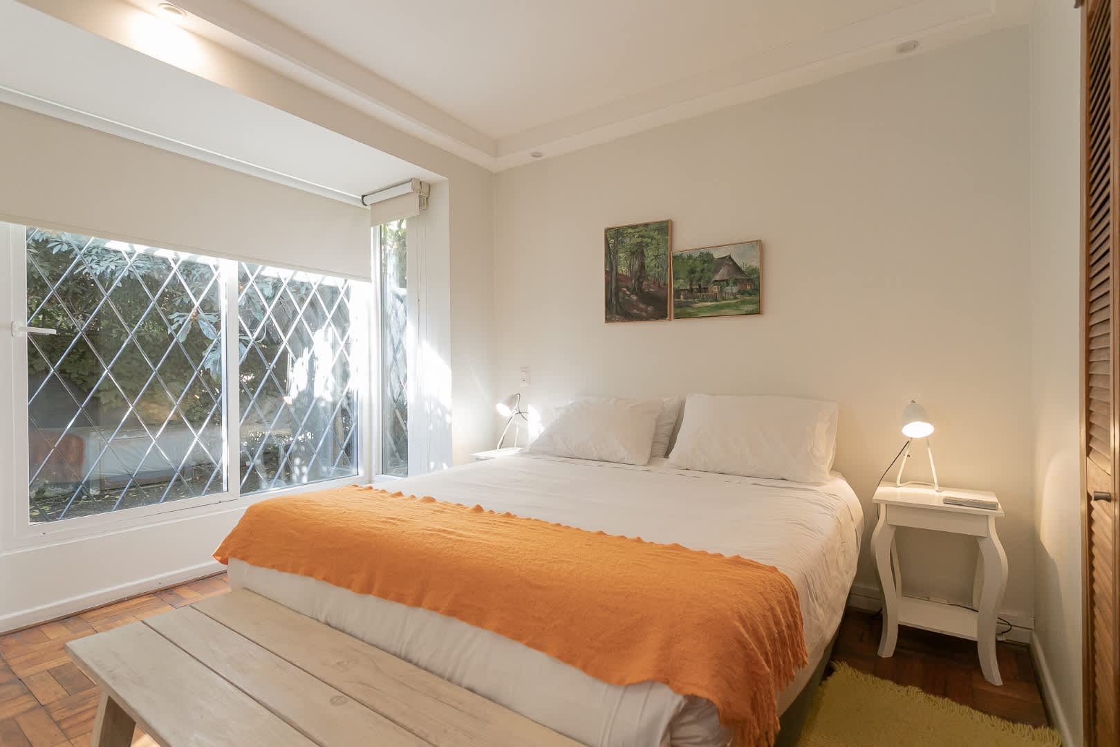 Relax in this bright and cozy bedroom with natural light and charming decor, perfect for a restful retreat.