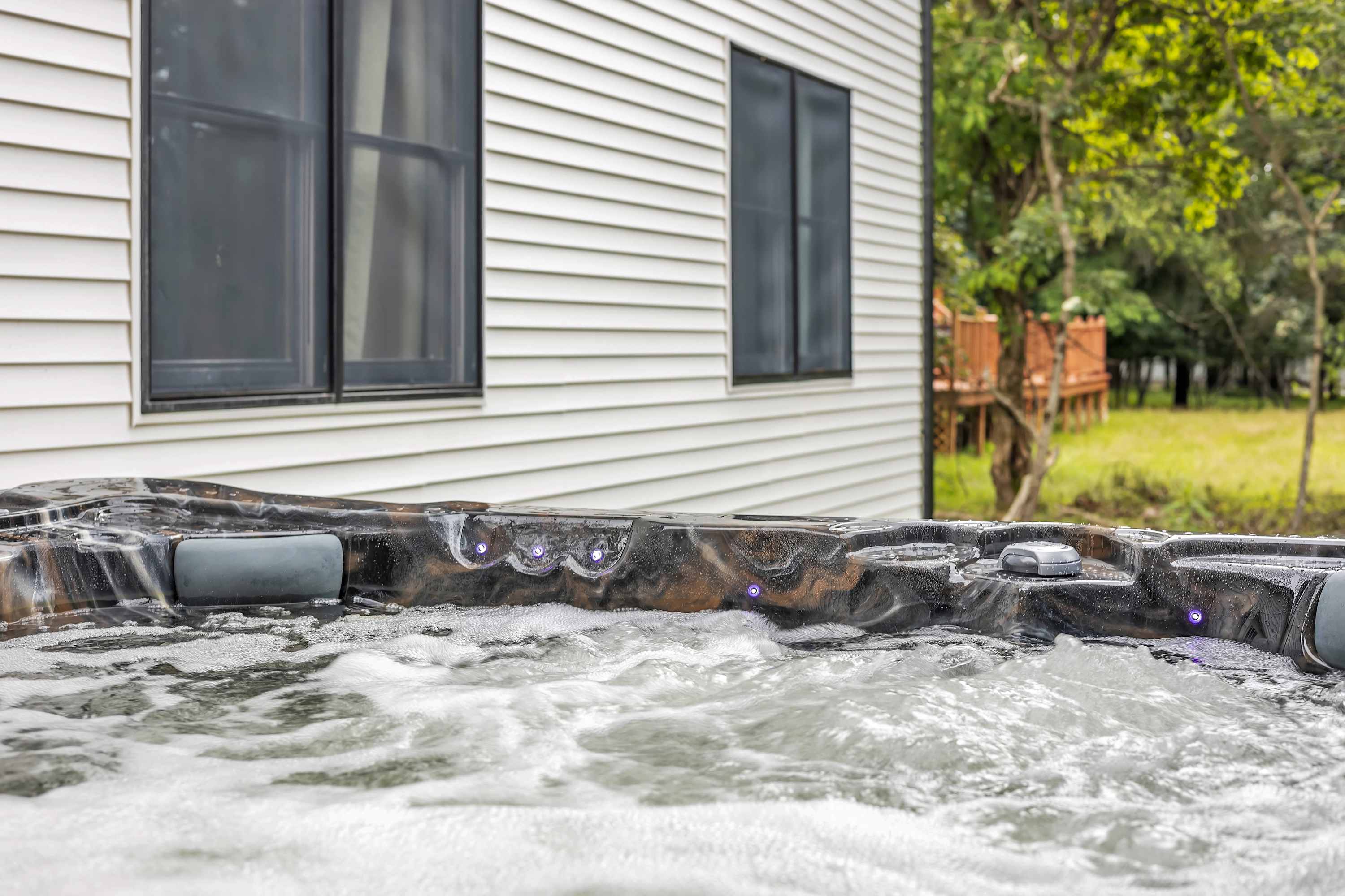 Peaceful Backyard Retreat – The perfect outdoor oasis featuring a bubbling hot tub, offering a quiet space to unwind and enjoy nature.