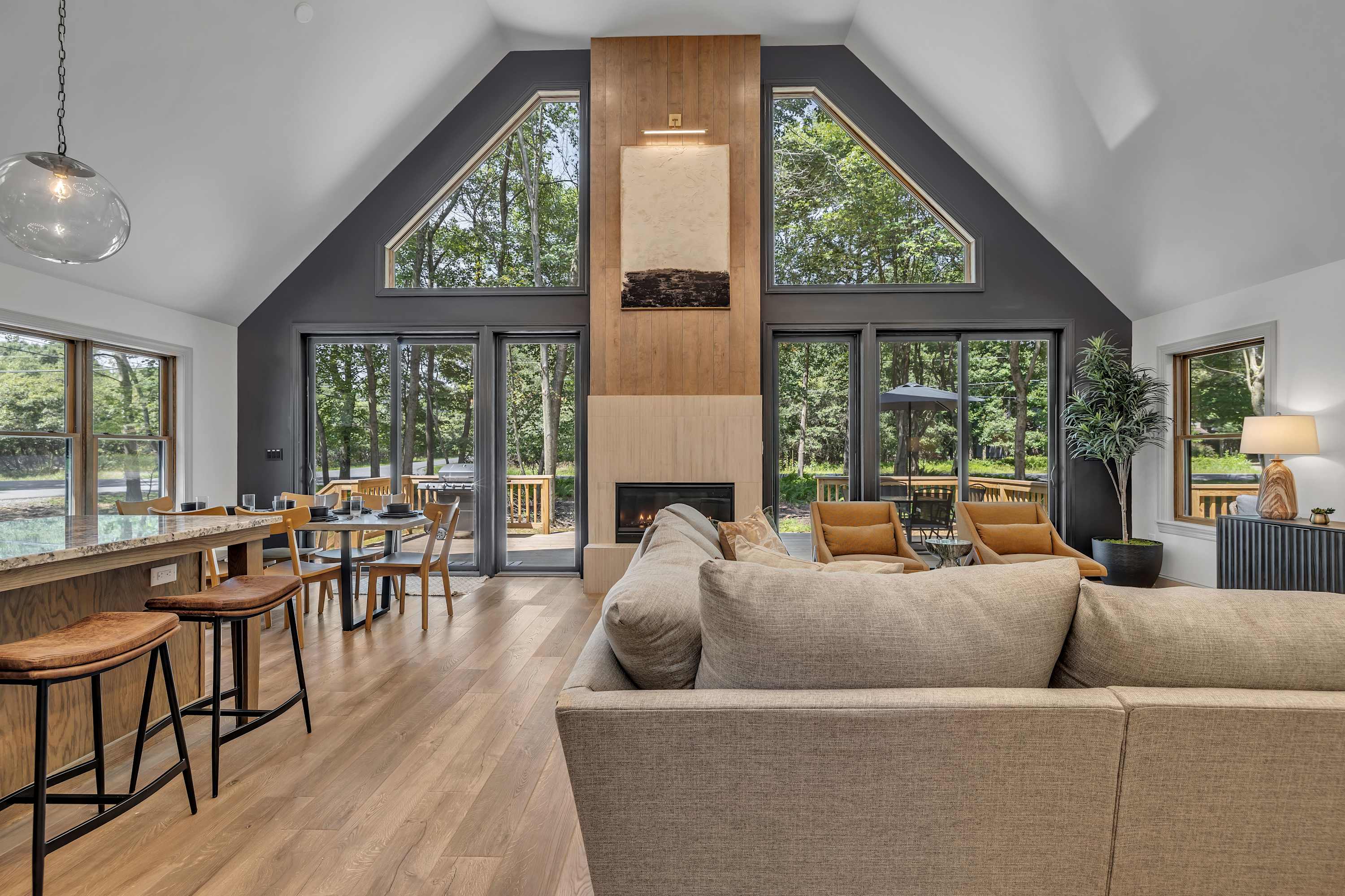 Bright & Open Living Space – A stunning open-concept living area with vaulted ceilings, modern decor, and floor-to-ceiling windows that bring in natural light.